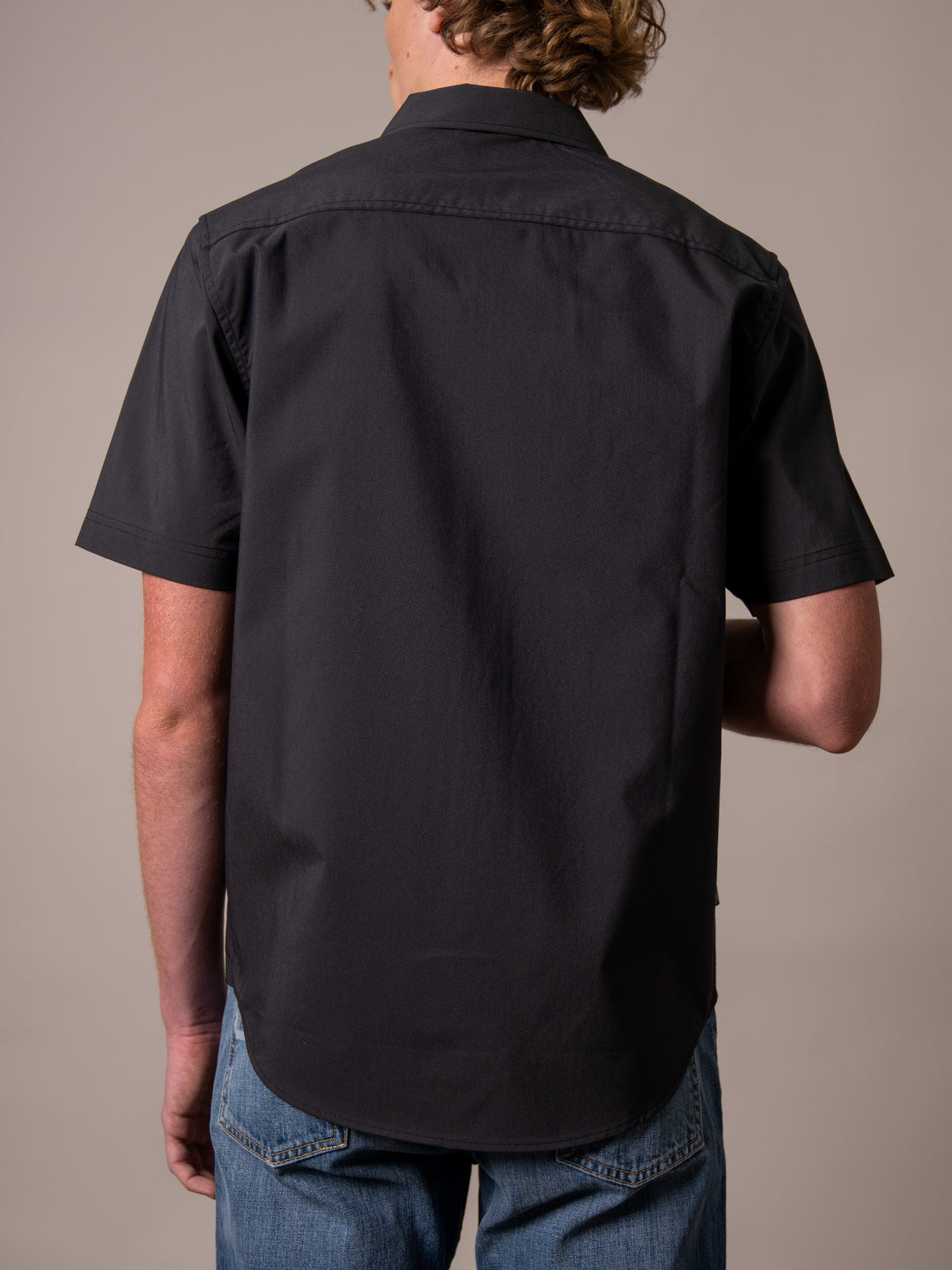 Kimes Ranch Linville Short Sleeve Dress Shirt in Black, back view, with a back yoke and curved hem