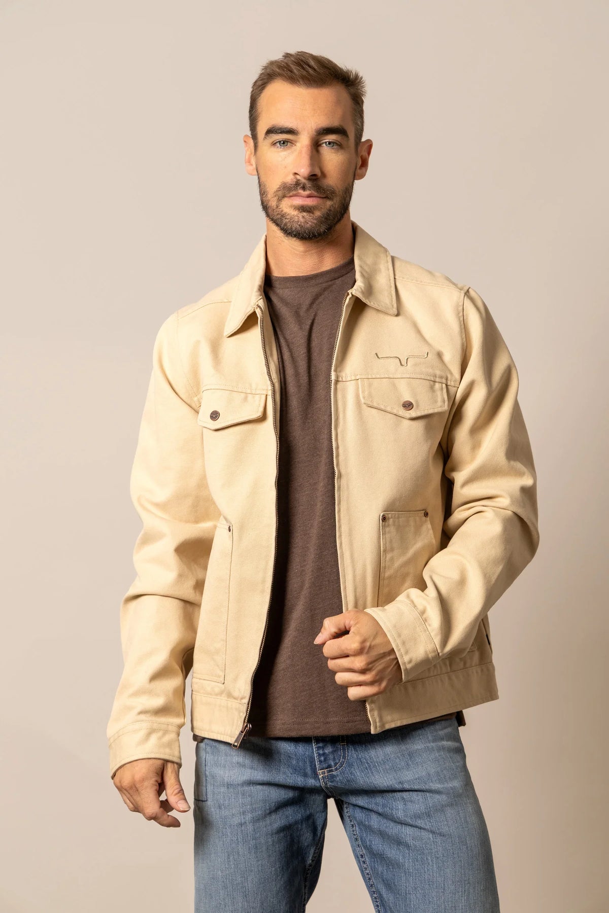 Kimes Ranch Logan Jacket in Tan with a collar, zip front, chest pockets with button flaps, and the Kimes Ranch logo