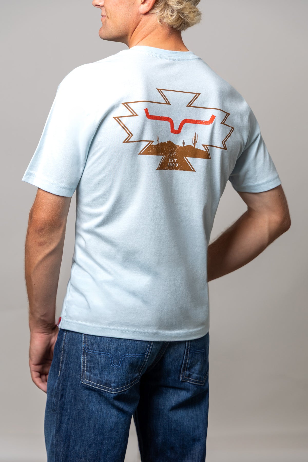 Kimes Ranch Long Live shirt in Light Blue, back view, with a back graphic of the Kimes Ranch logo over a desert landscape