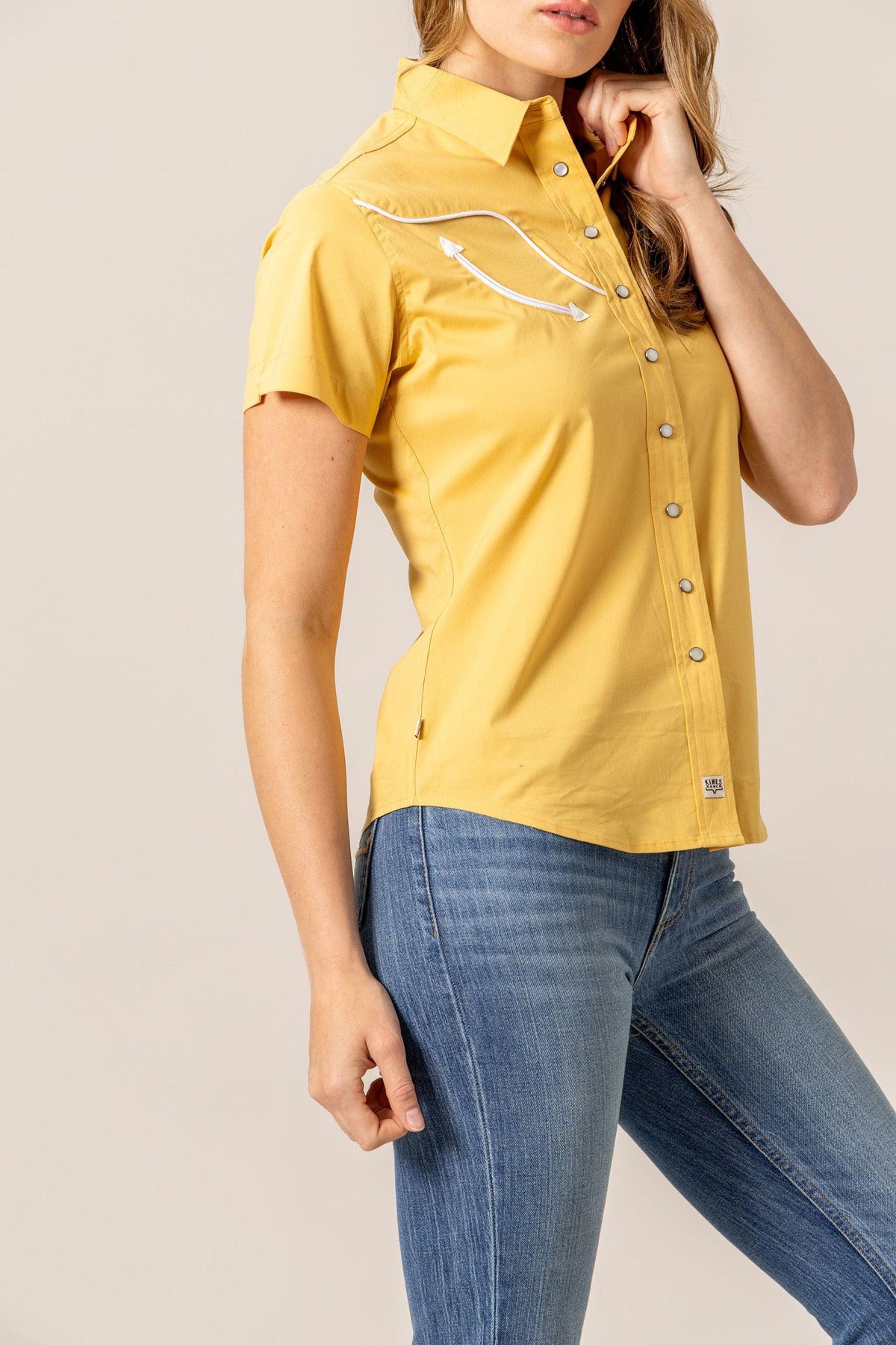 Kimes Ranch Logo Horn Snap top in Gold, side view, with white piping and snap buttons