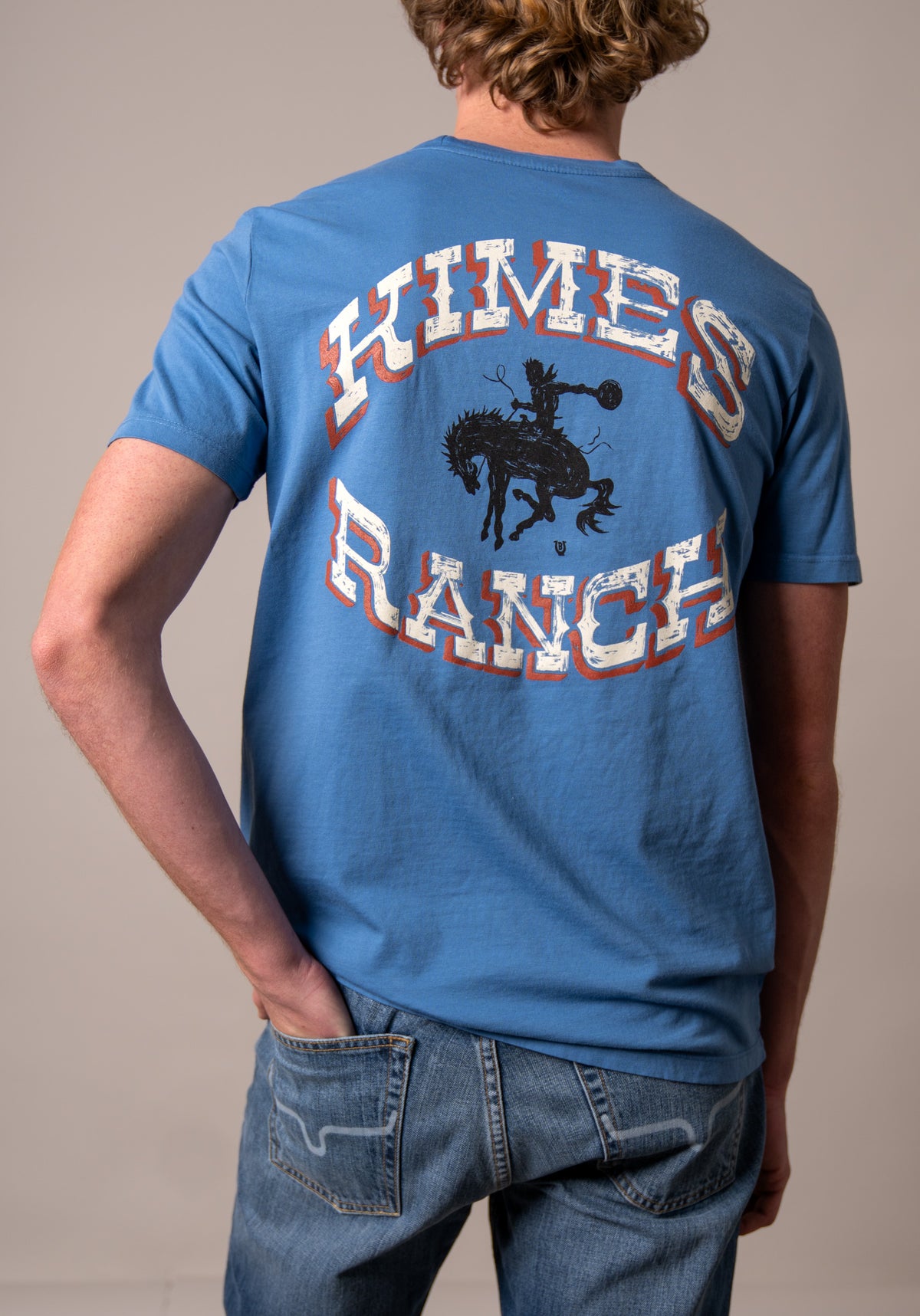 Kimes Ranch Lucky B Bucking shirt in Mid Blue, back view, with a back graphic of a cowboy on a bucking horse