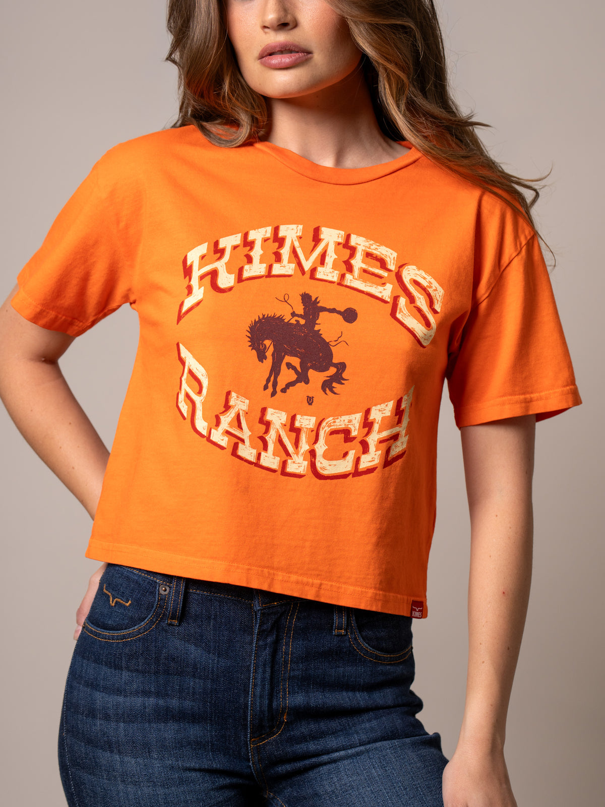 Kimes Ranch Lucky B Bucking shirt in Vintage Orange with a graphic of a cowboy riding a bucking horse