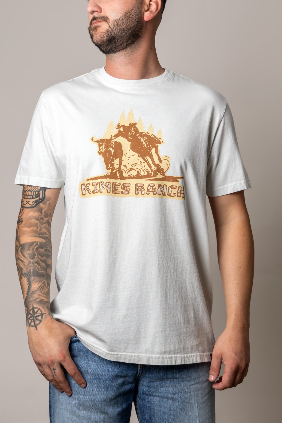 Kimes Ranch Lucky B Bull Dogger shirt in Muted White with a graphic of a cowboy wrestling a steer and the Kimes Ranch logo