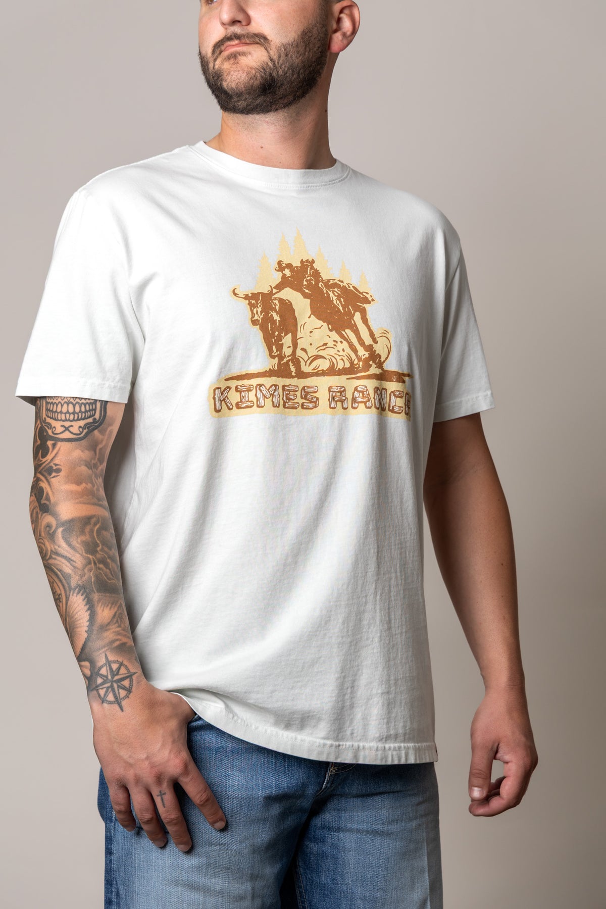 Kimes Ranch Lucky B Bull Dogger shirt in Muted White with a graphic of a cowboy wrestling a steer and the Kimes Ranch logo