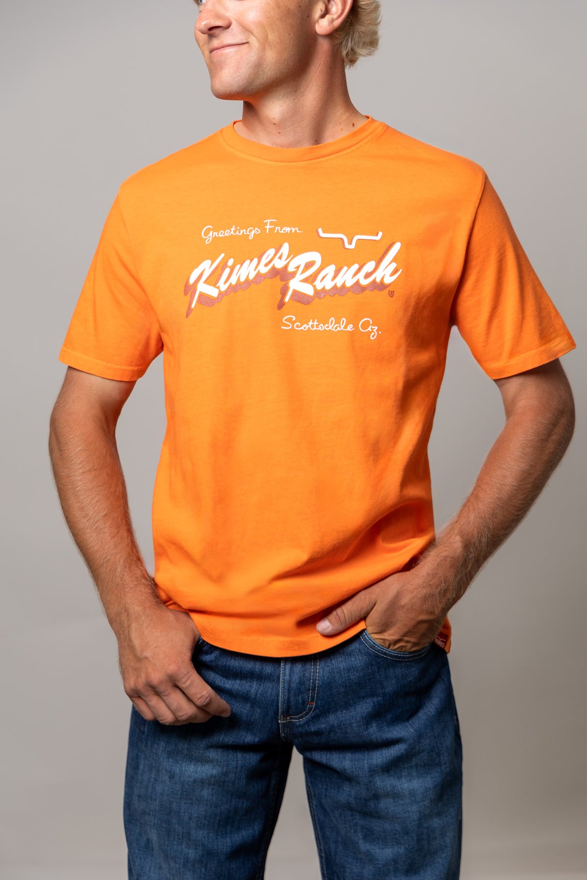 Kimes Ranch Lucky B Greetings shirt in Vintage Orange with a front graphic reading Greetings From Kimes Ranch Scottsdale Az