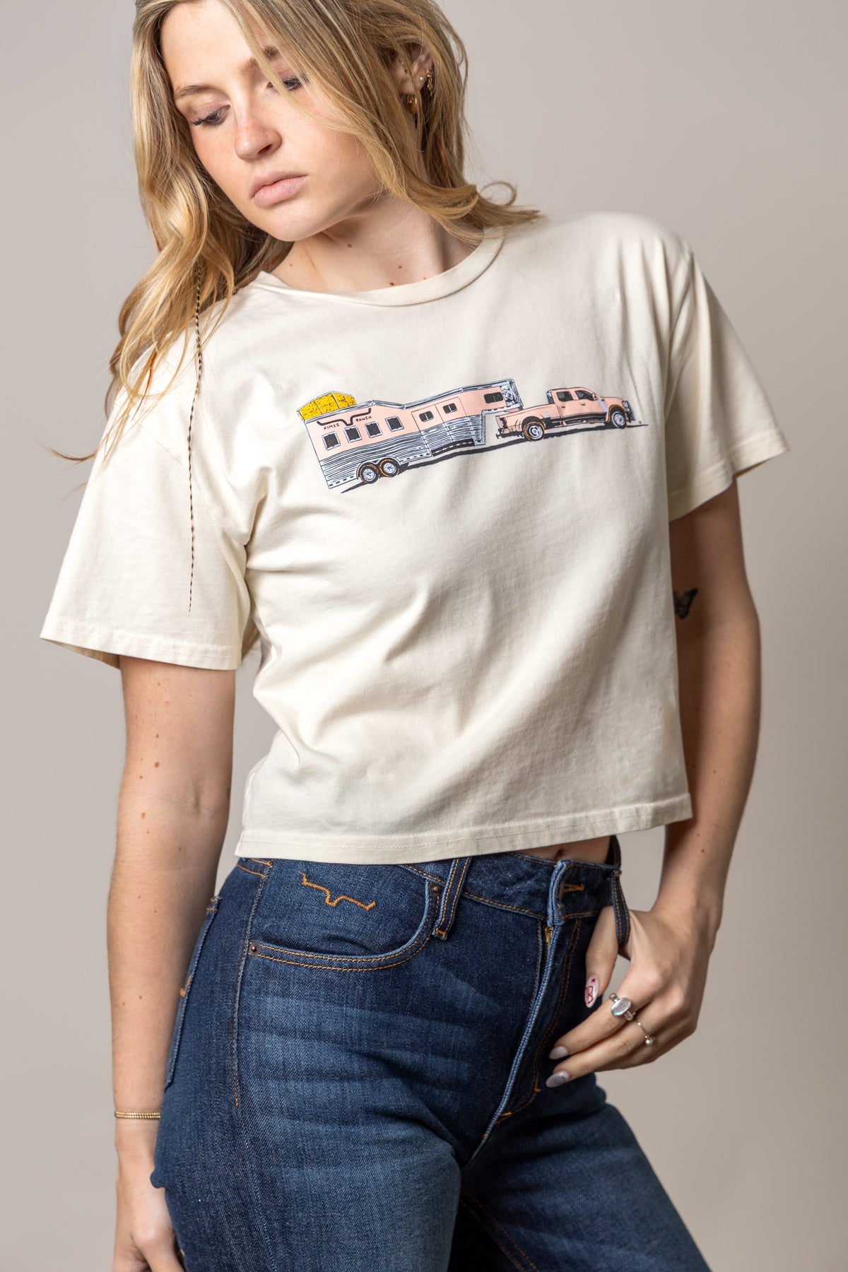 Kimes Ranch Lucky B Hauler shirt in Ivory with a graphic of a pink truck towing a camper trailer
