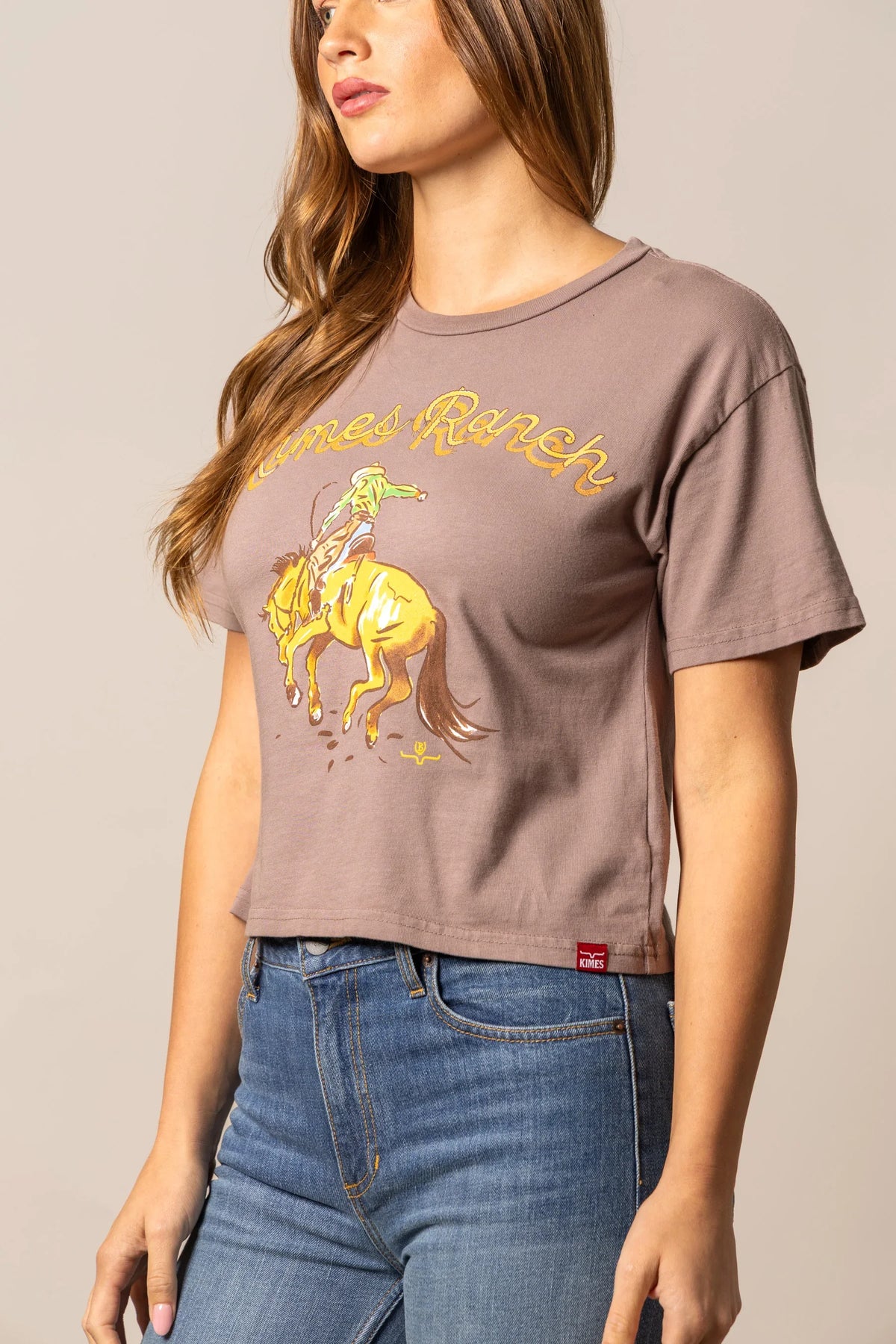 Kimes Ranch Lucky B Rodee-oh! Mocha short sleeve shirt with a graphic of a cowboy riding a bucking horse and Kimes Ranch logo