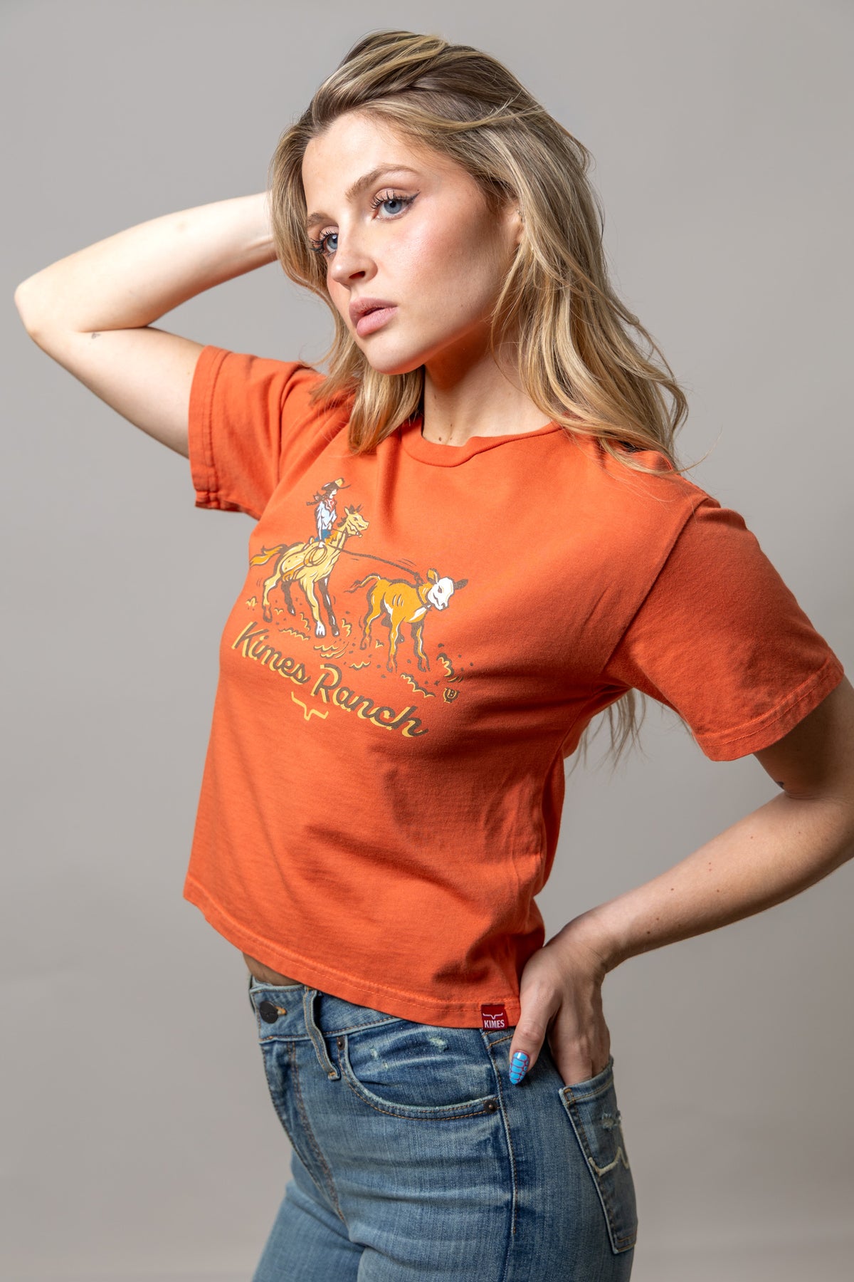 Kimes Ranch Lucky B Roper, side view, Spice Red short sleeve shirt with a cowboy roping a calf graphic and Kimes Ranch text