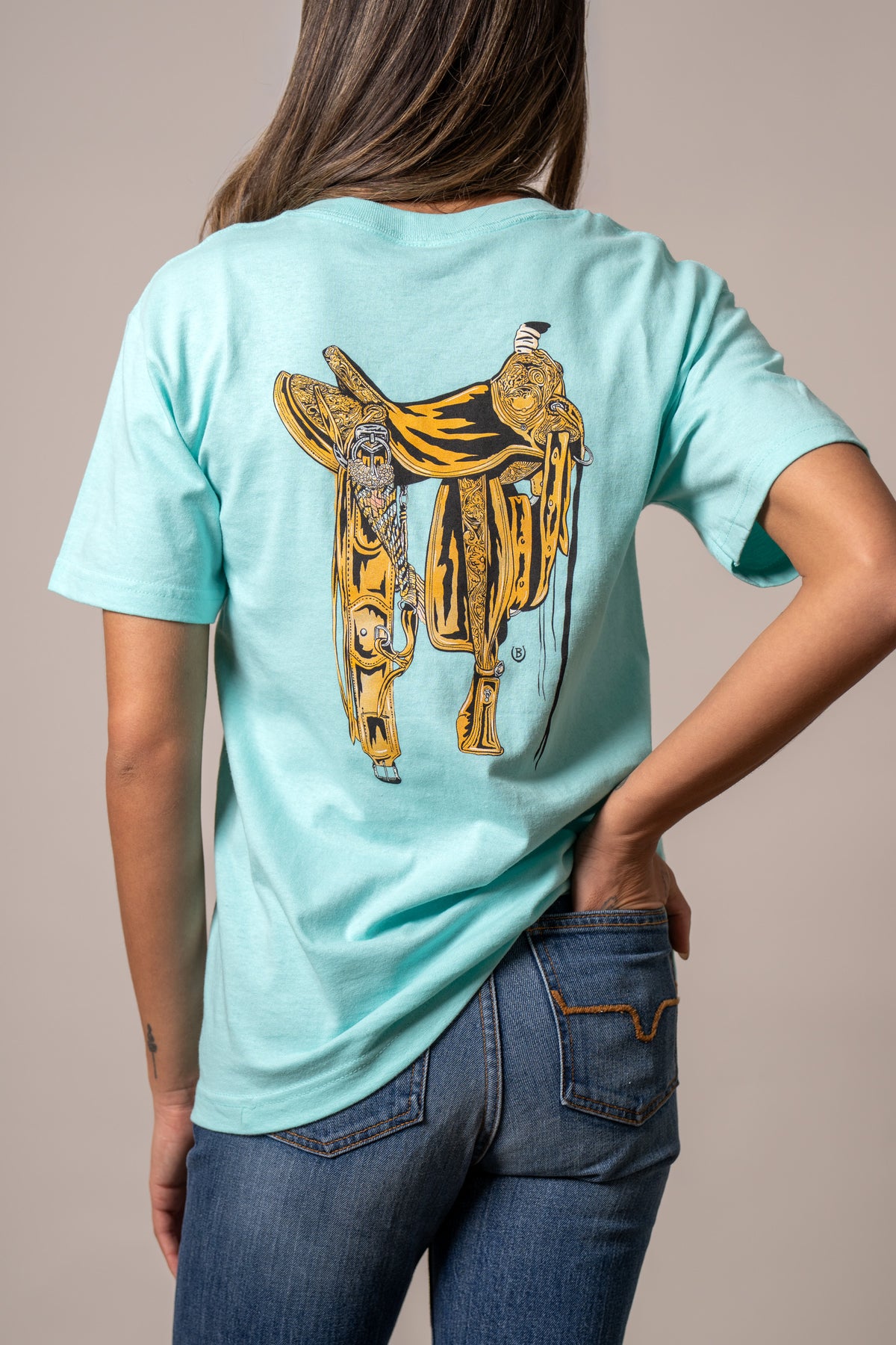 Kimes Ranch Lucky B Saddle shirt in Light Blue, back view, with a large detailed western saddle graphic on the back