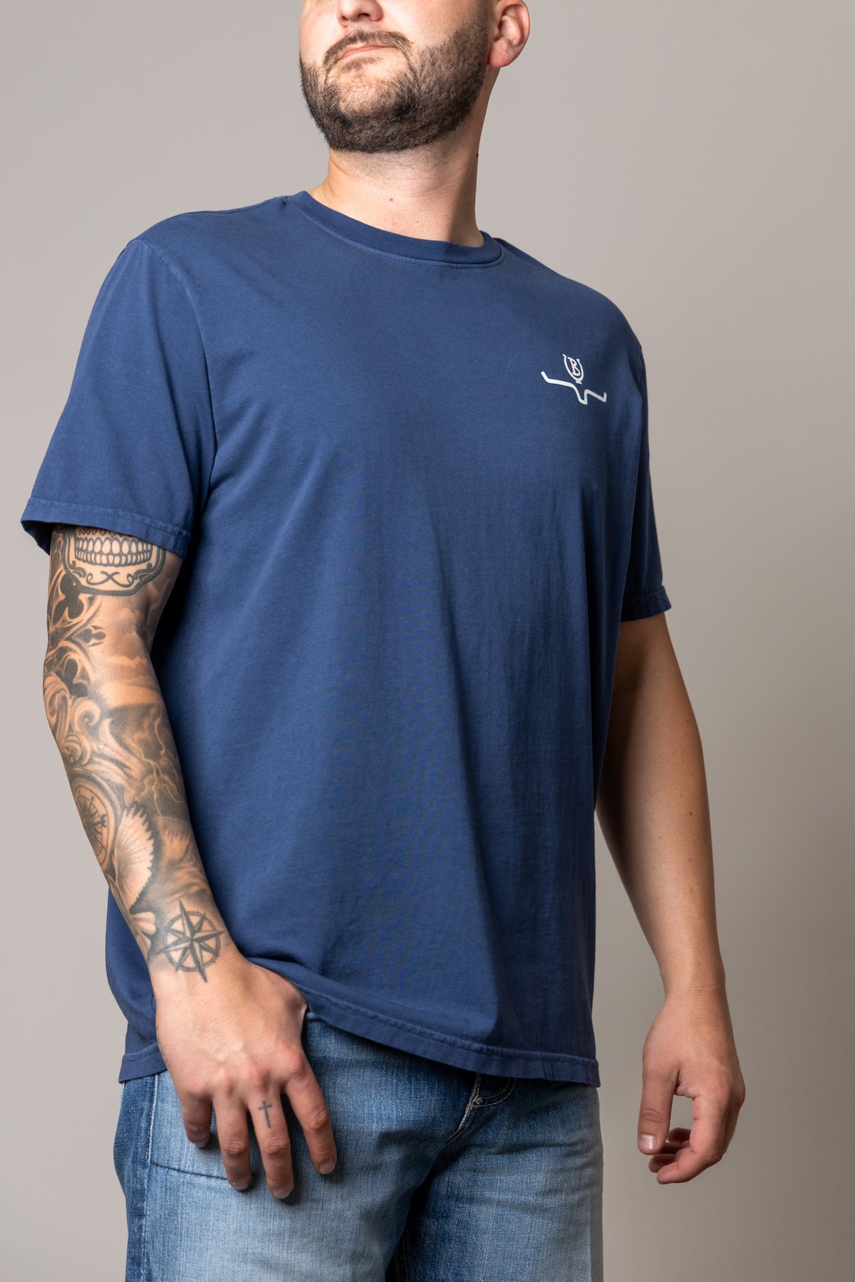 Kimes Ranch Lucky B Statewide shirt in Indigo, side view, with a crew neck and short sleeves and a white logo on the chest