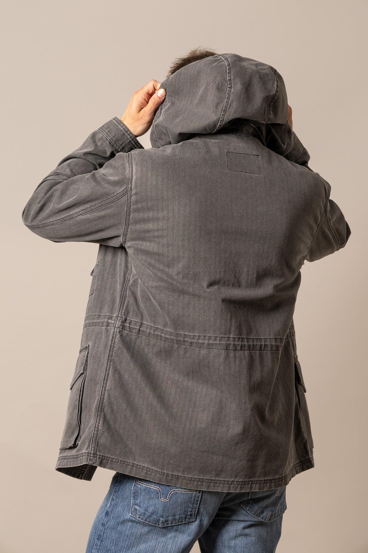 Kimes Ranch M65 S Jacket in Black, back view, with a hood, back yoke, and side pockets