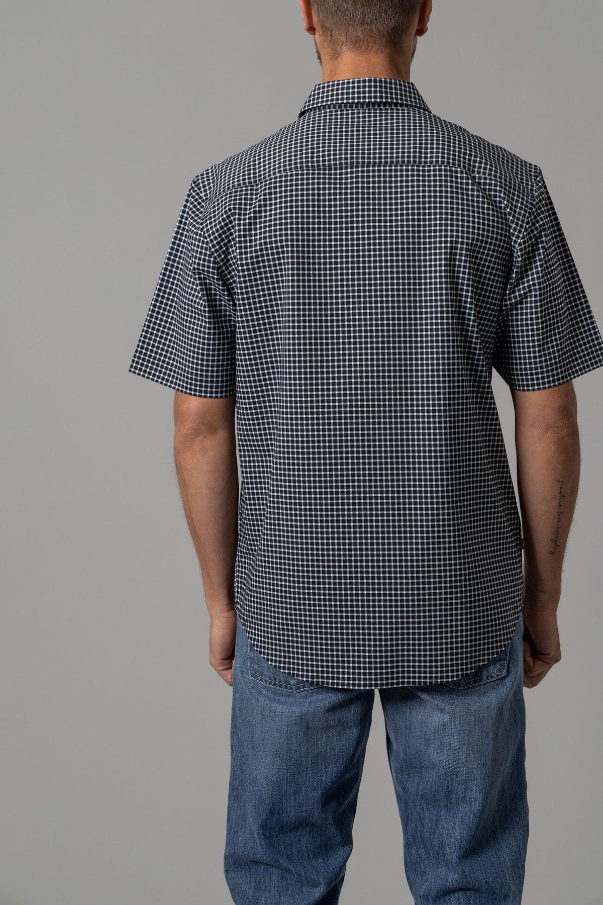 Kimes Ranch MC Cooper, back view, Black dress shirt with short sleeves and a checkered pattern