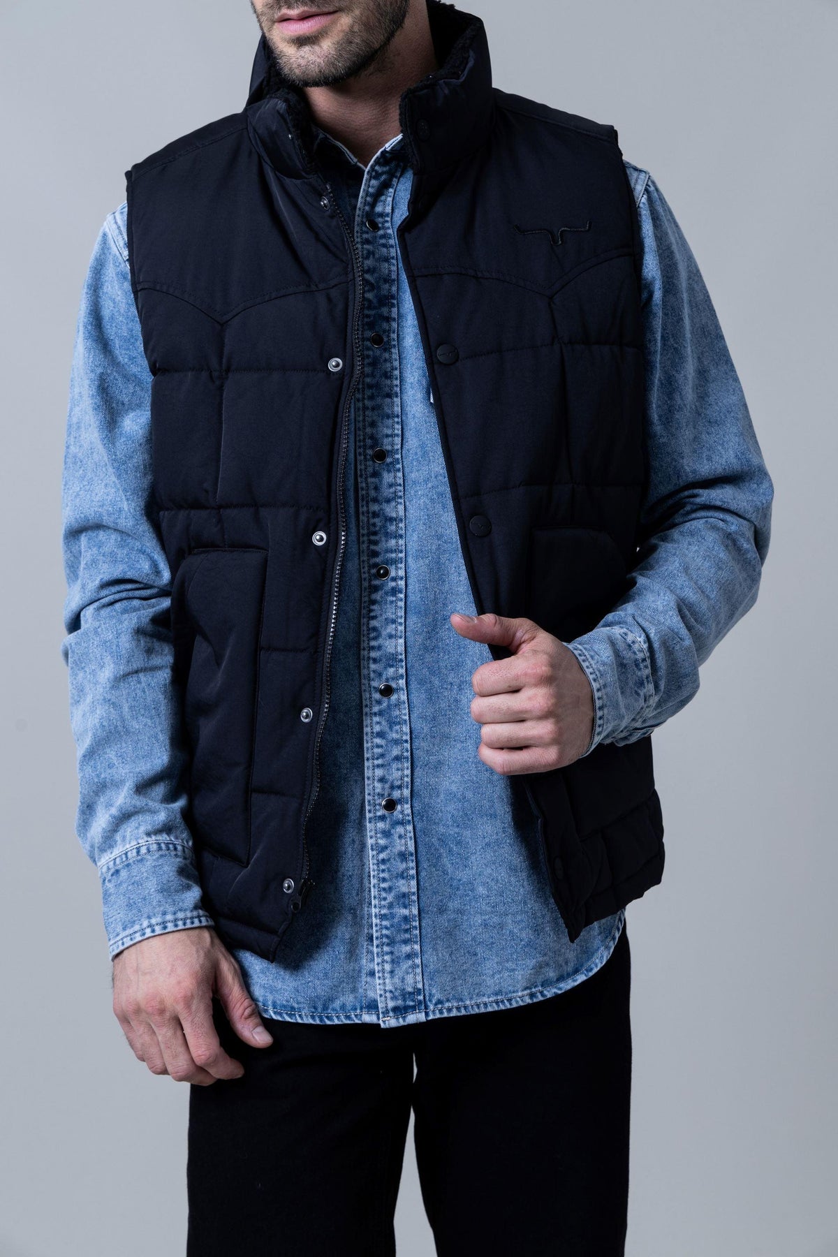 Kimes Ranch Muir Trail Vest in Black with a stand collar, zip front, snap placket, and chest logo