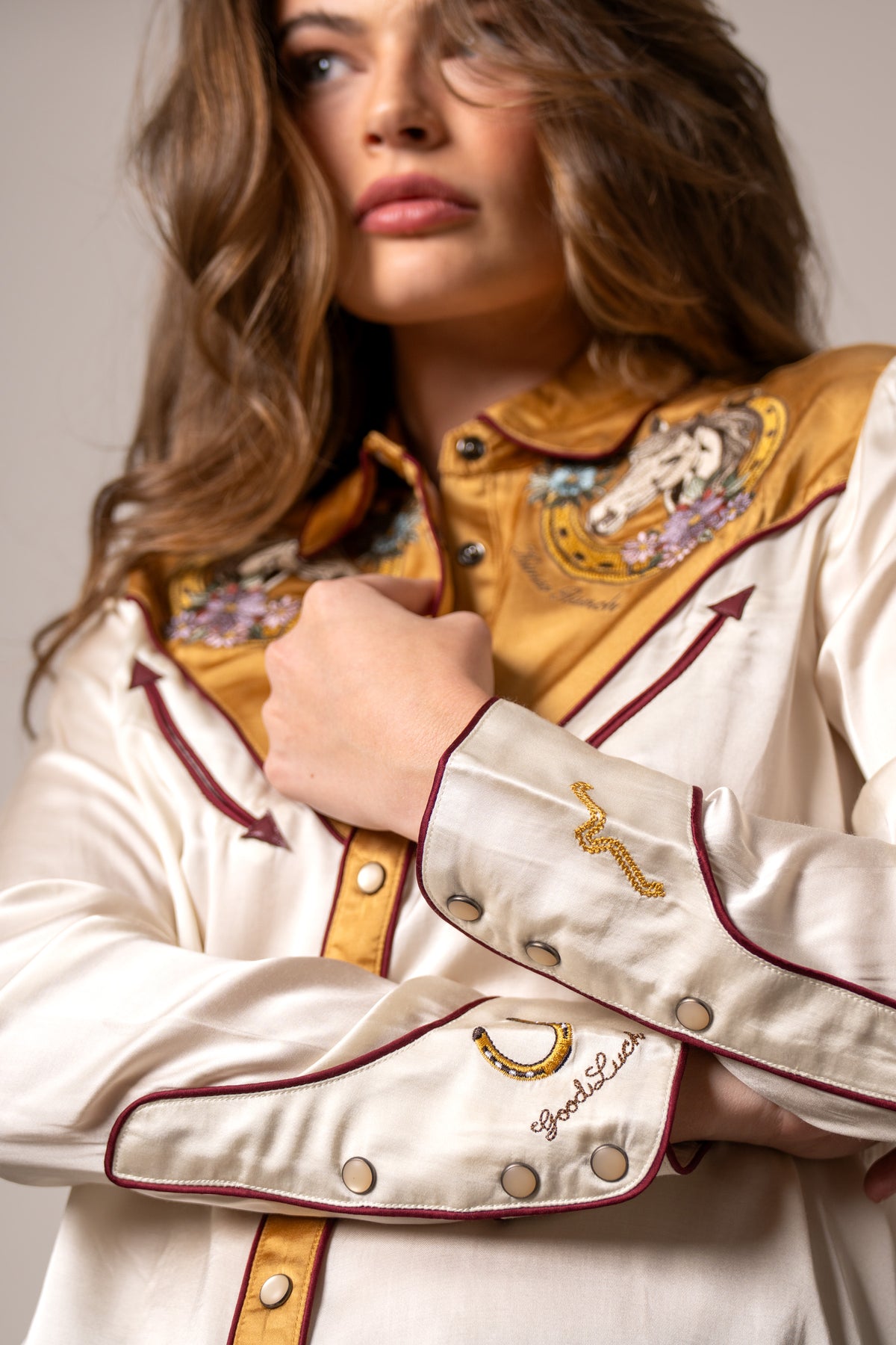 Kimes Ranch Merada top in Soft Gold, close-up, with embroidered horseshoe and Good Luck on the cuffs