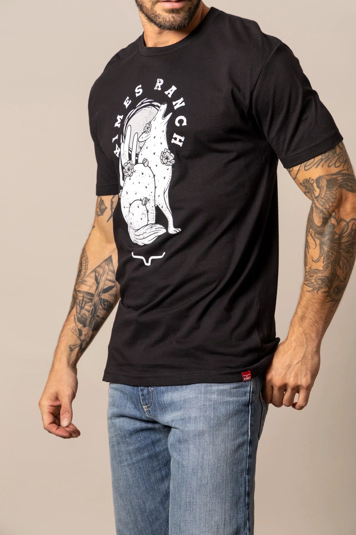 Kimes Ranch Night Call Black shirt with a white graphic of a howling coyote with flowers and the text KIMES RANCH