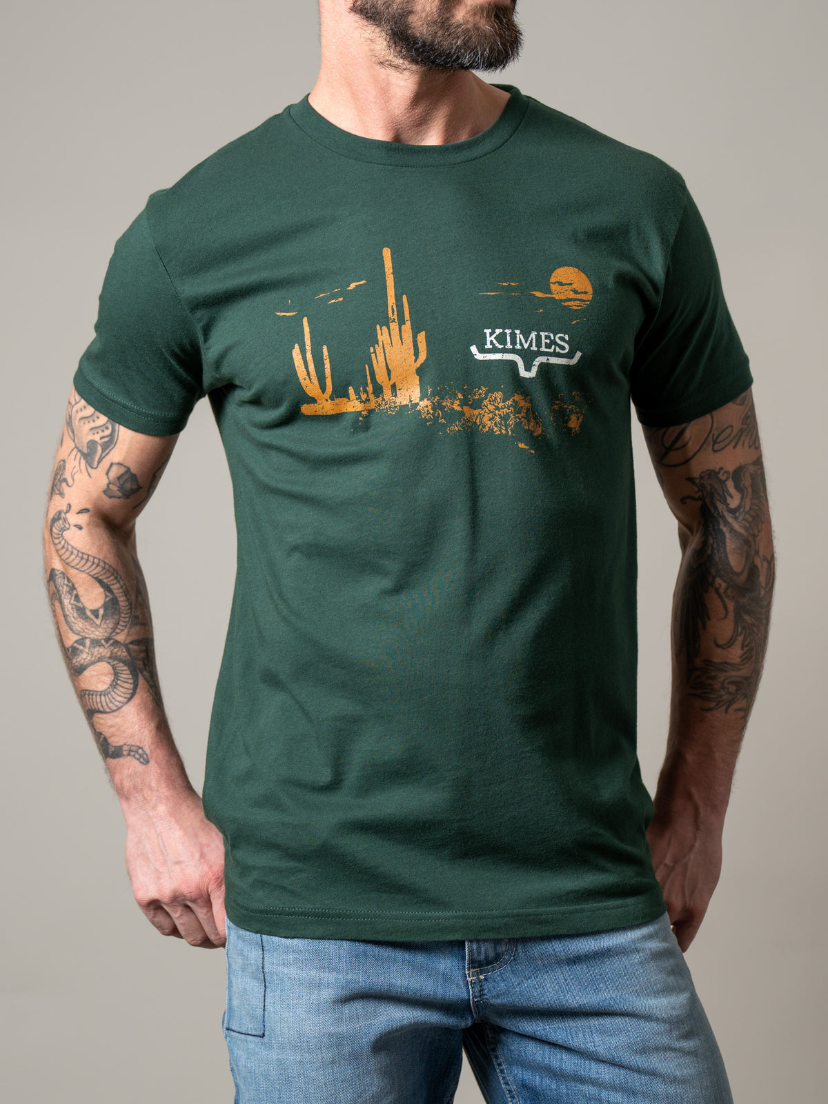 Kimes Ranch Night Fall Heather Forest Green t-shirt with a desert sunset graphic and Kimes Ranch logo