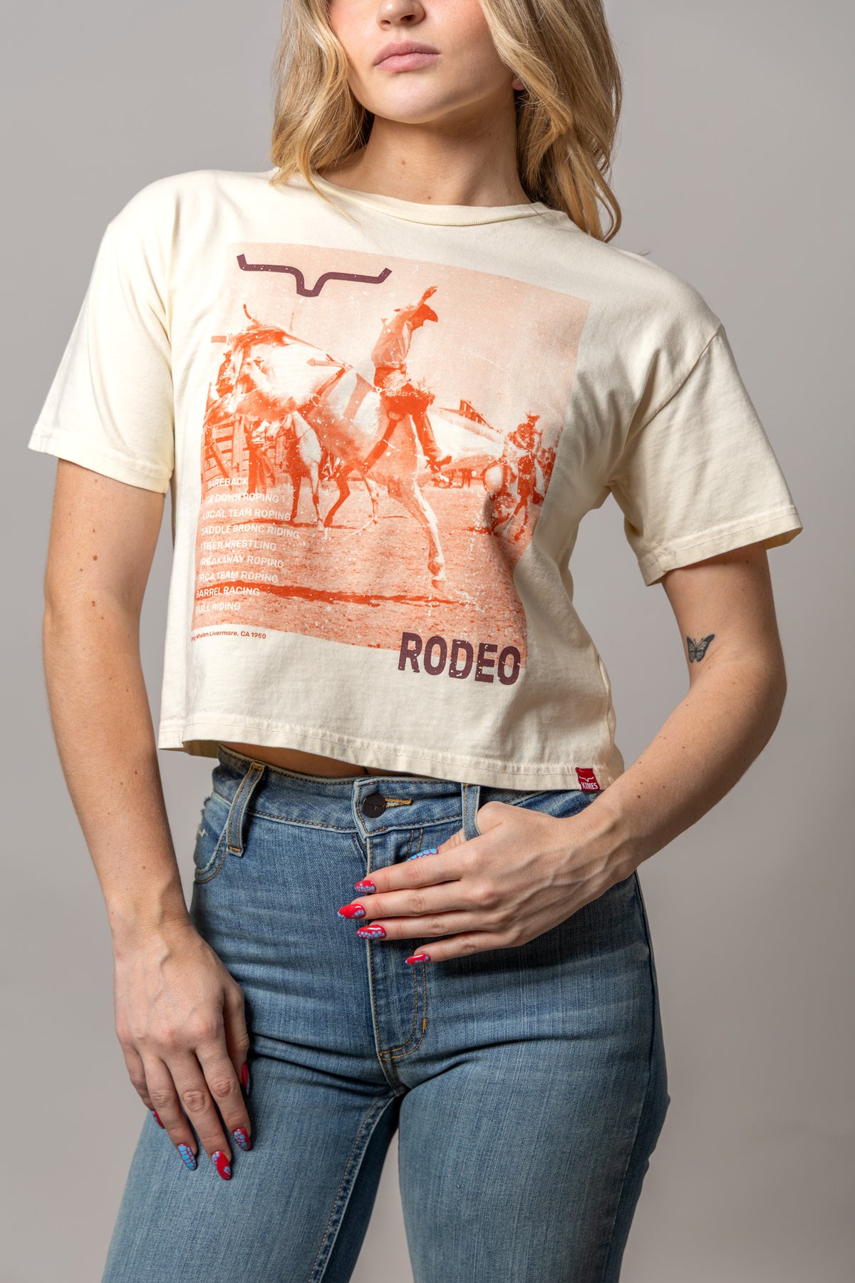 Kimes Ranch Not Our First shirt in Ivory with a rodeo graphic and RODEEO text