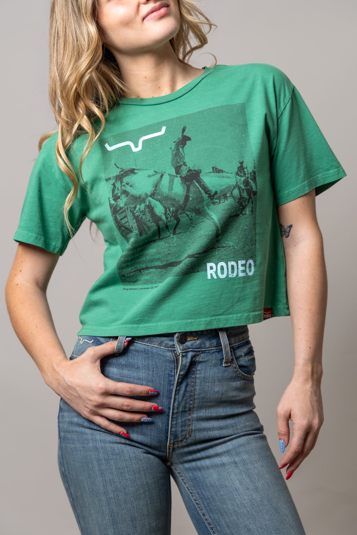 Kimes Ranch Not Our First green short sleeve shirt with a rodeo graphic and RODEEO text