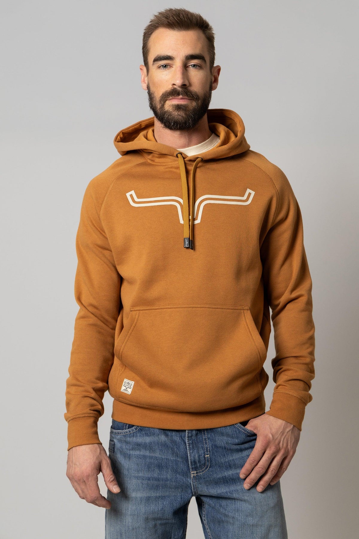 Kimes Ranch Outlier Hoodie in Work Wear Brown with a white graphic on the chest and a front kangaroo pocket
