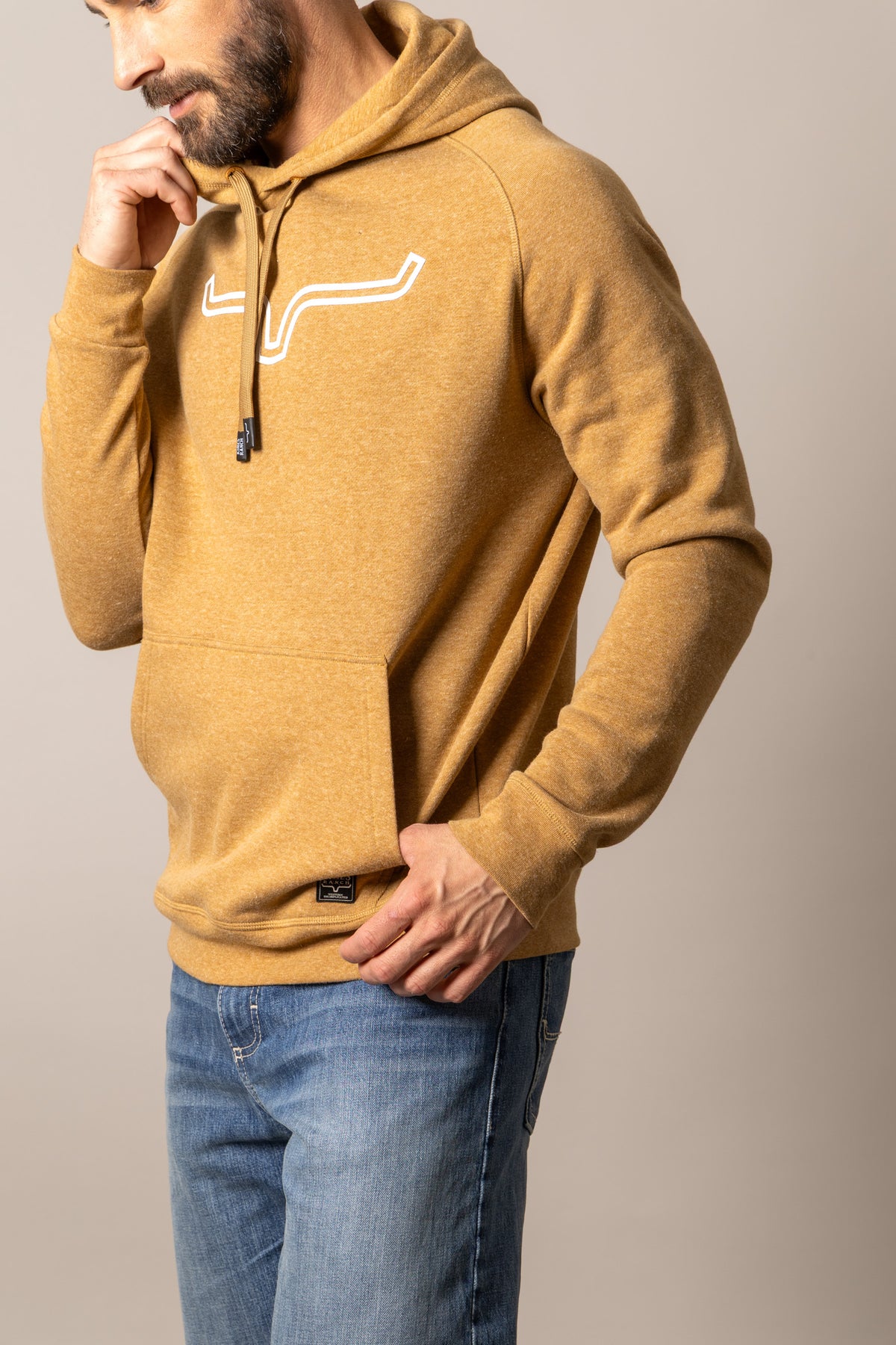 Kimes Ranch Outlier Hoodie in Rust Heather, side view, with a white logo graphic on the chest and a front kangaroo pocket