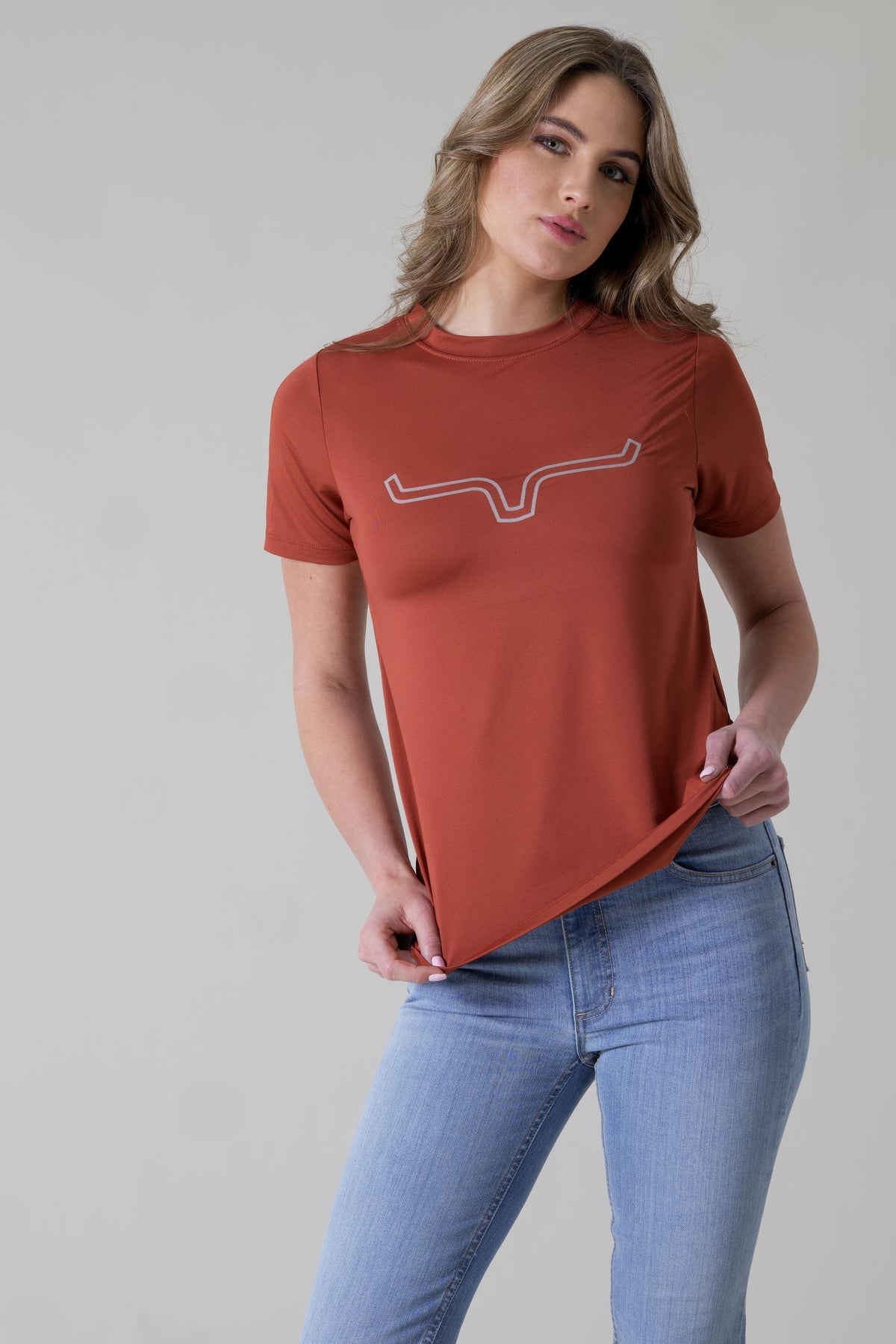 Kimes Ranch Ladies Outlier Tech Tee Shirt in Rust with a white logo outline on the chest