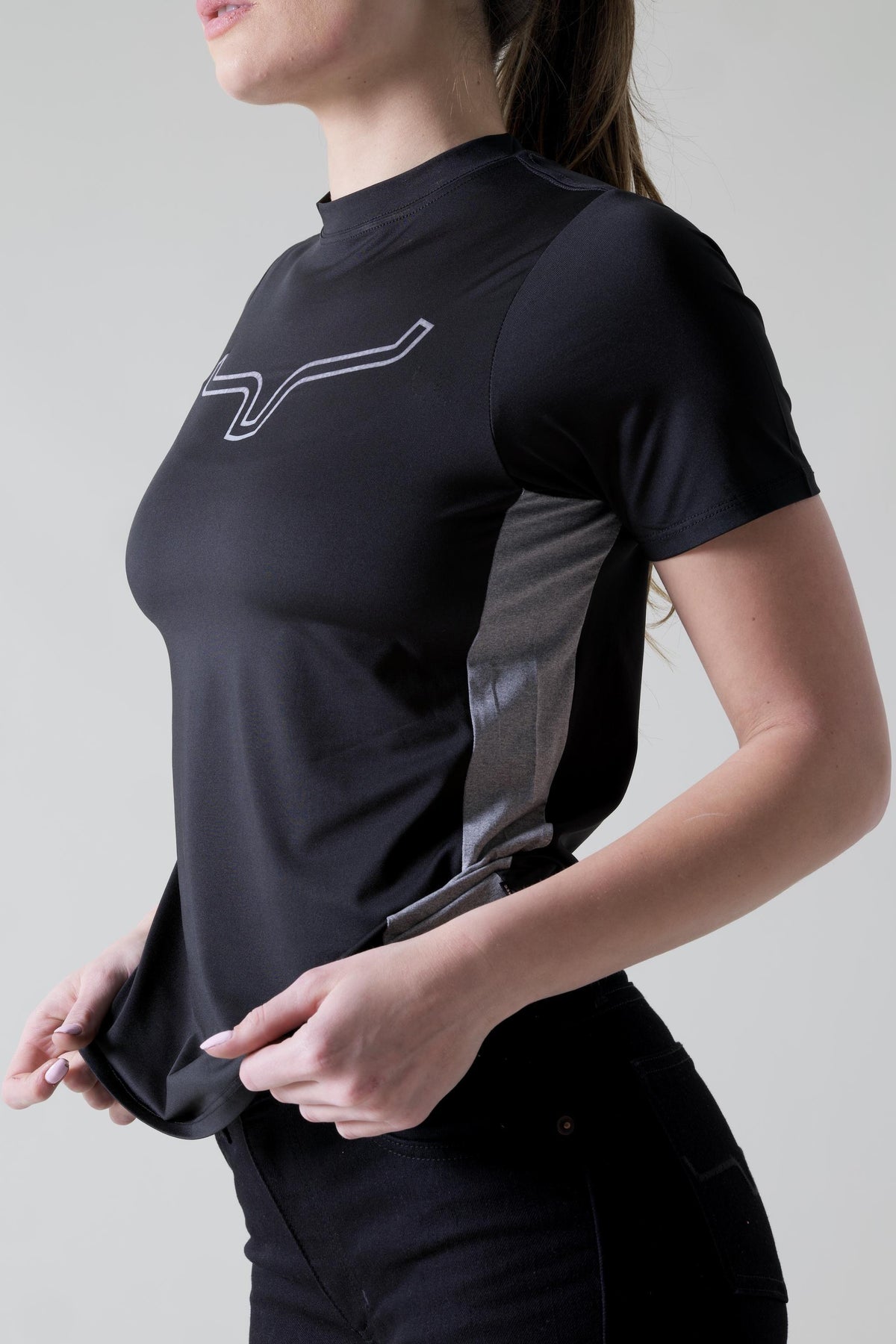 Kimes Ranch Ladies Phase 2 Tech Shirt in Black, side view, with a white logo and grey side panel