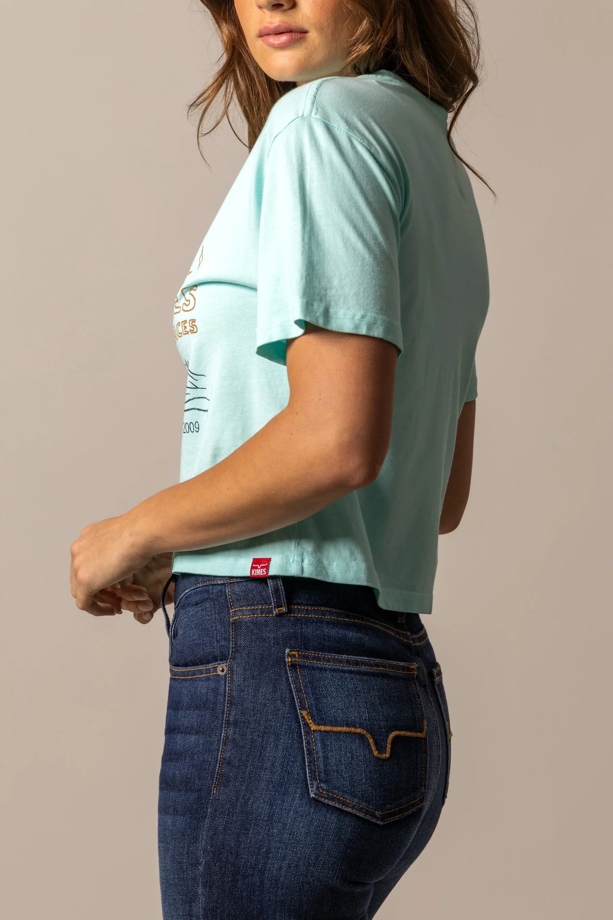 Kimes Ranch Places shirt in Mint, side view, with the short sleeves and a graphic print on the front