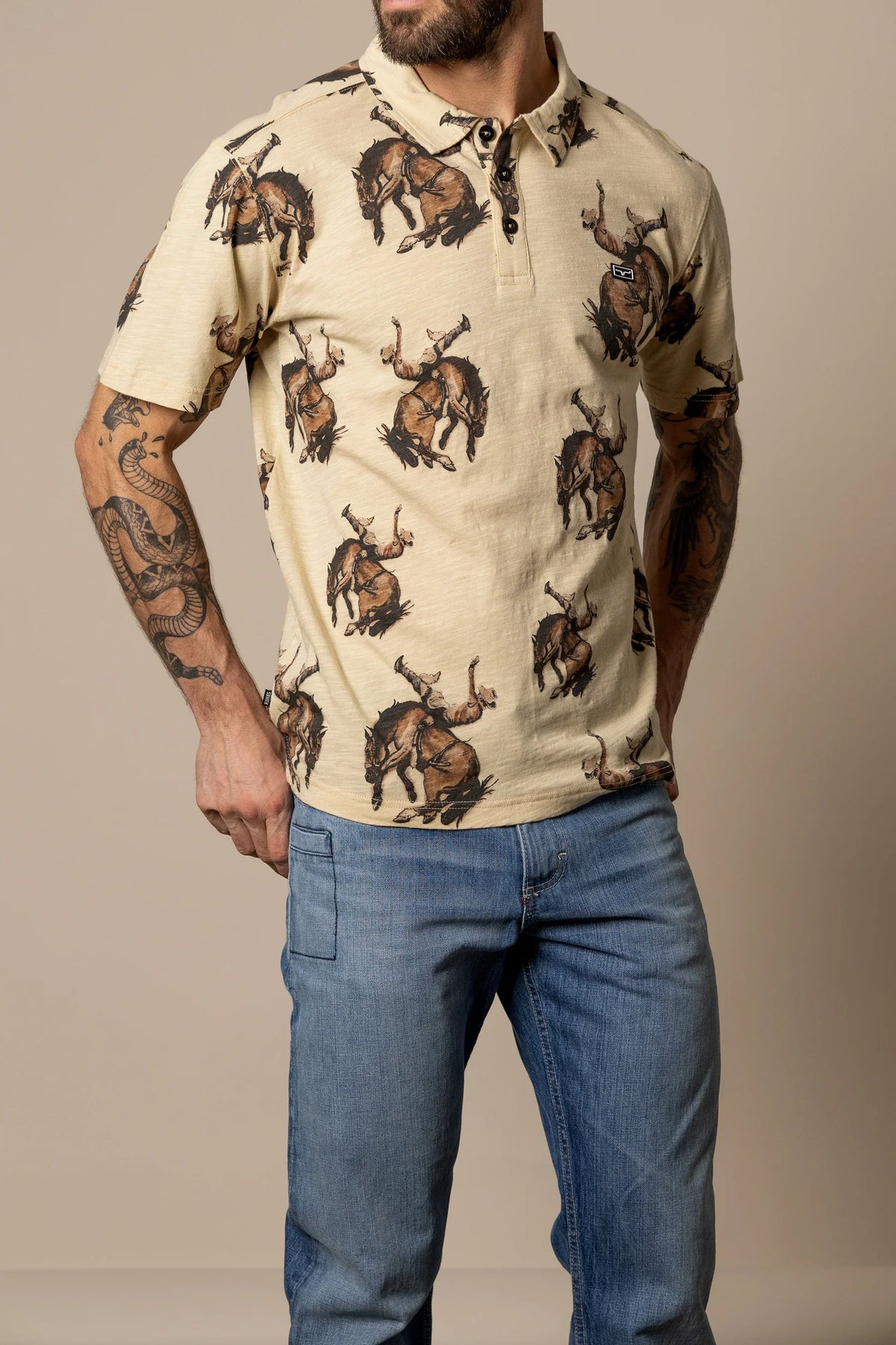 Kimes Ranch RP Winning Ride Polo in Tan with an all-over print of cowboys riding bucking broncos