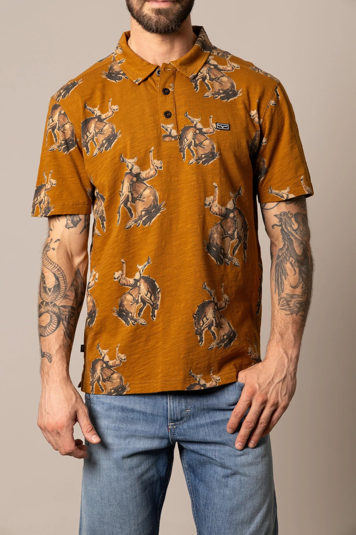 Kimes Ranch RP Winning Ride Polo in Work Wear Brown with a cowboy riding a bucking bronco print and a logo patch