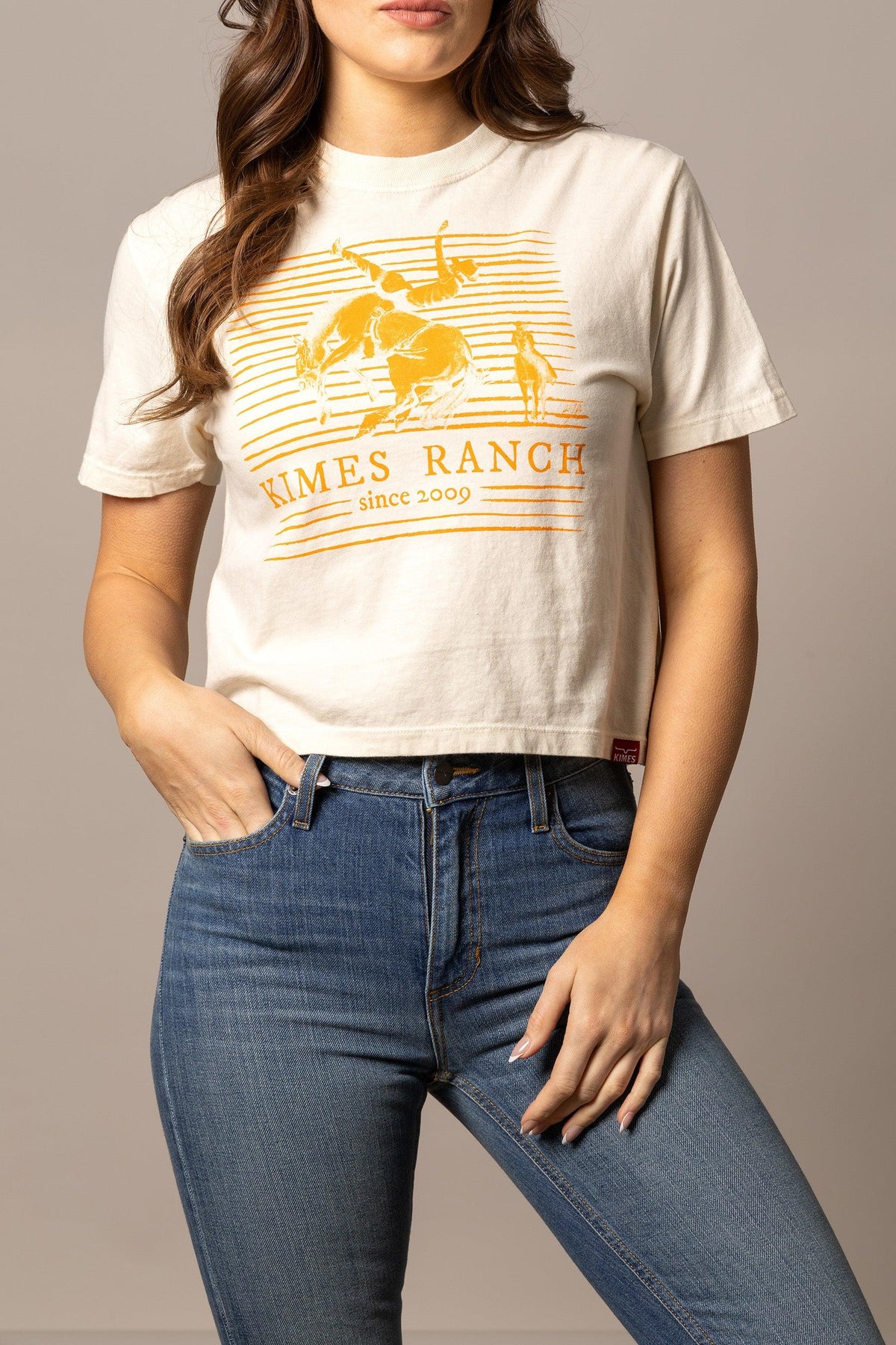 Kimes Ranch Randy Bareback shirt in Ivory with a graphic of a cowboy on a bucking horse and Kimes Ranch since 2009 text