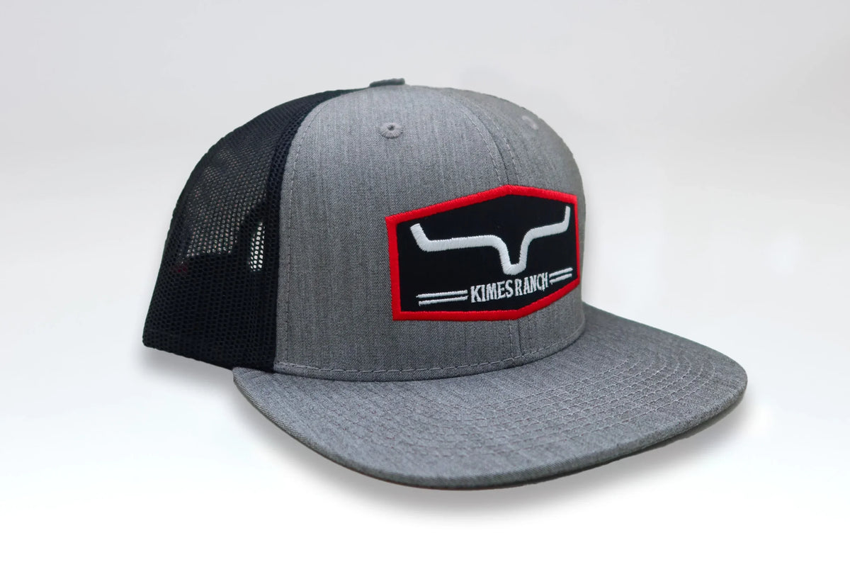 Kimes Ranch Replay Trucker Hat in Heather Grey, side view, with a black mesh back and red-bordered logo patch
