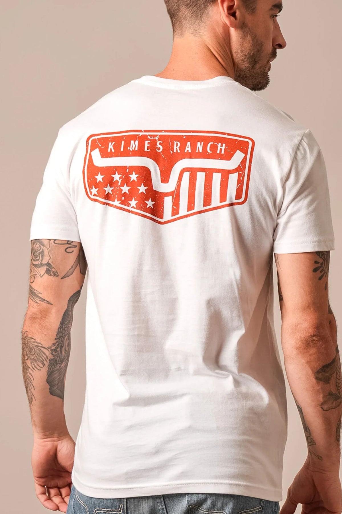 Kimes Ranch Spangled shirt in White, back view, with a large orange back graphic featuring the Kimes Ranch logo and stars