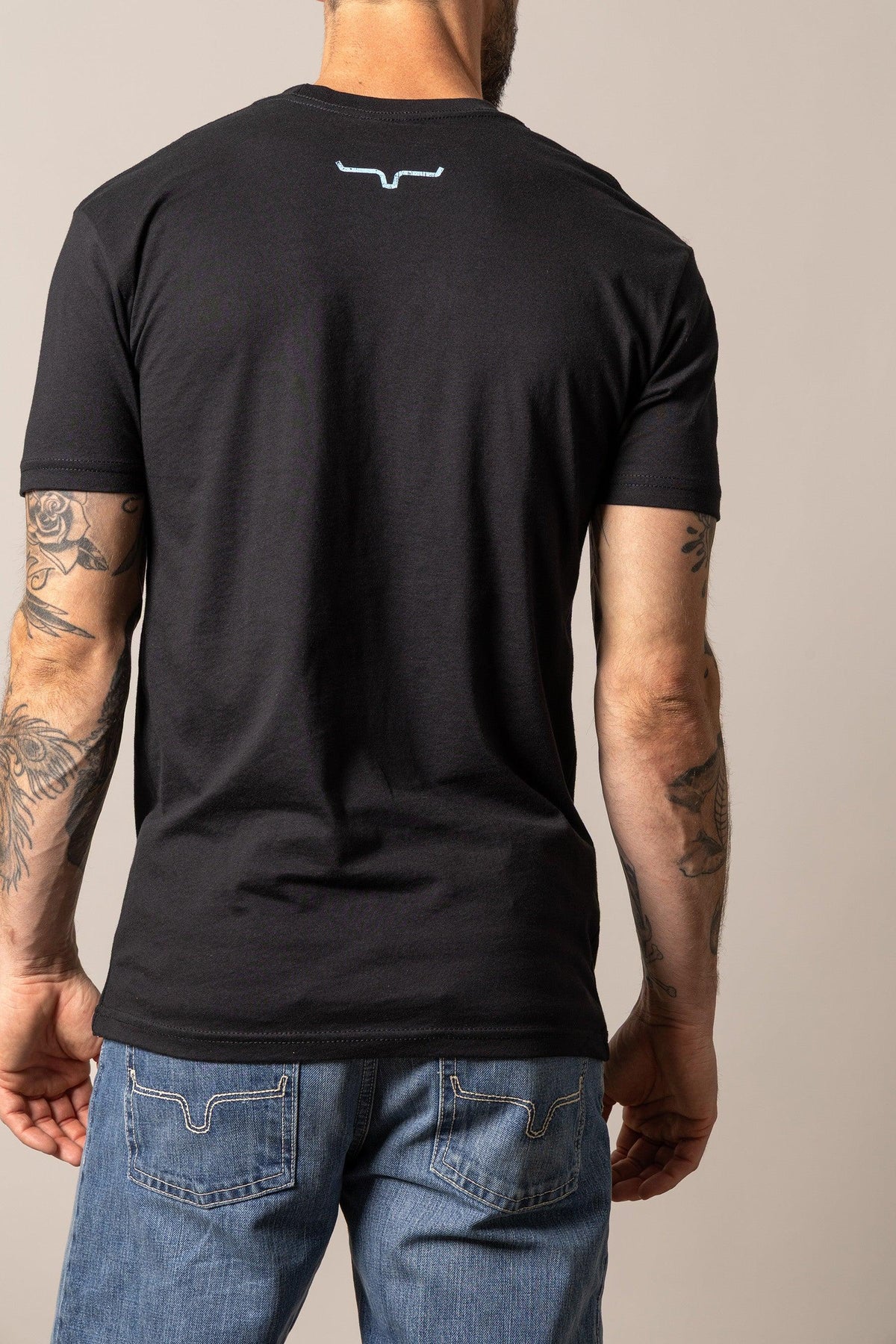 Kimes Ranch Stability, back view, Black short sleeve shirt with the Kimes Ranch logo at the back yoke