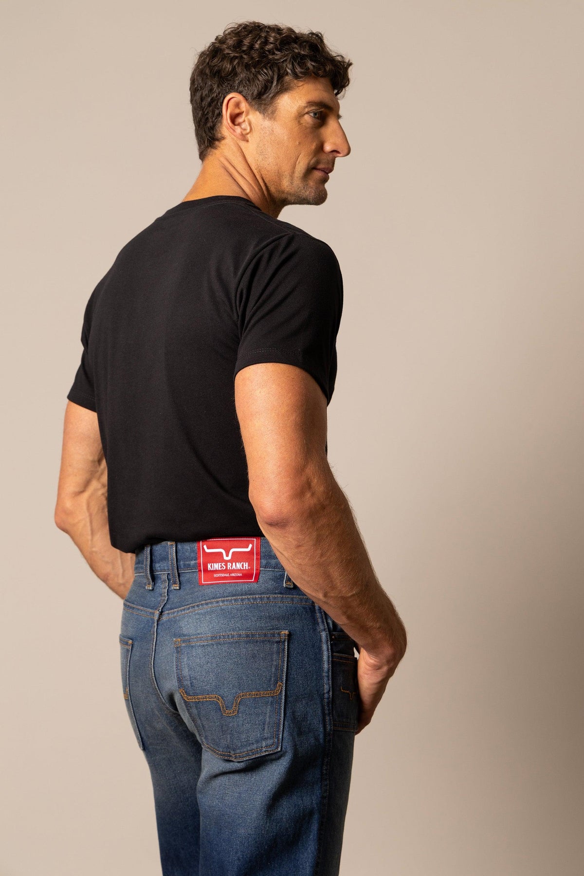 Kimes Ranch Stewart Relaxed Bootcut jeans in blue with a red Kimes Ranch logo patch at the back waistband