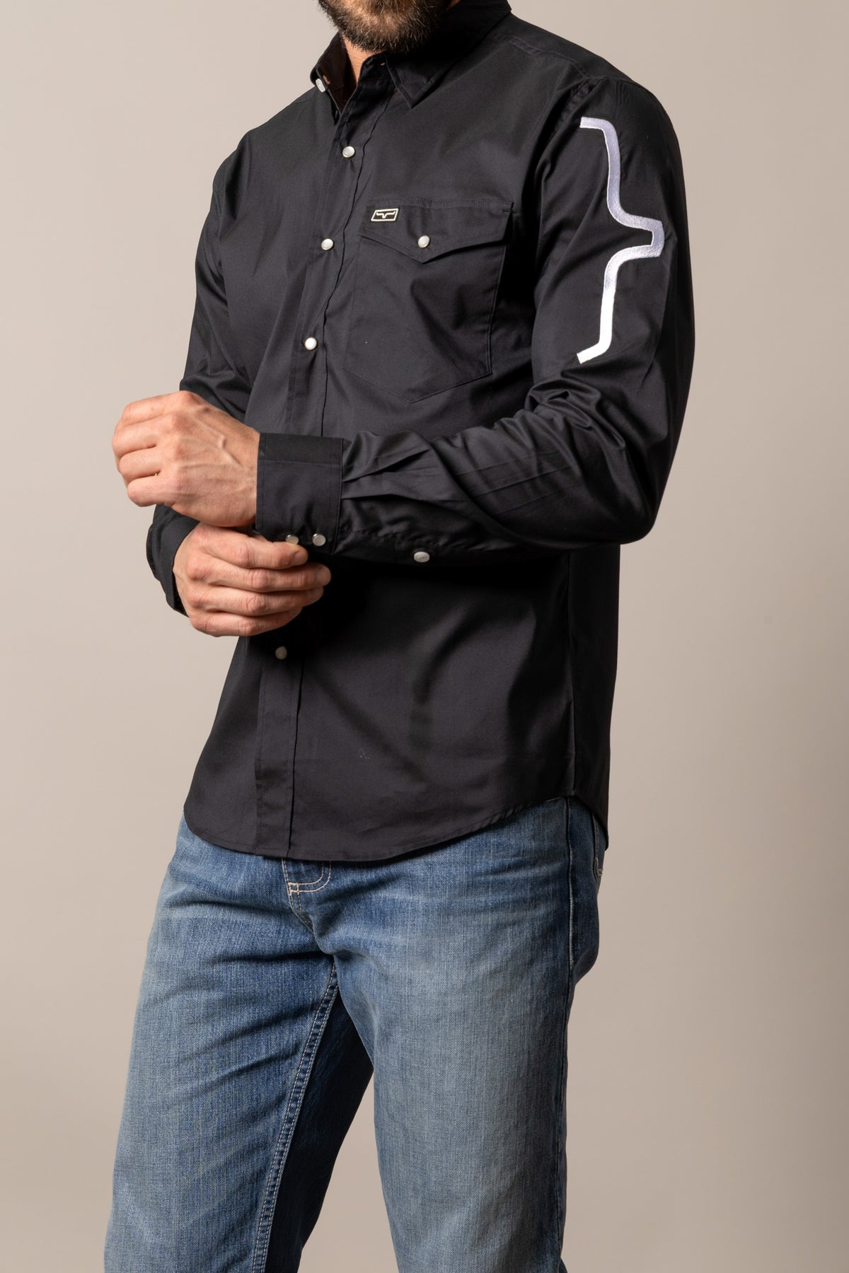 Kimes Ranch Talbott, side view, Black long sleeve dress shirt with a chest pocket and a white logo on the sleeve