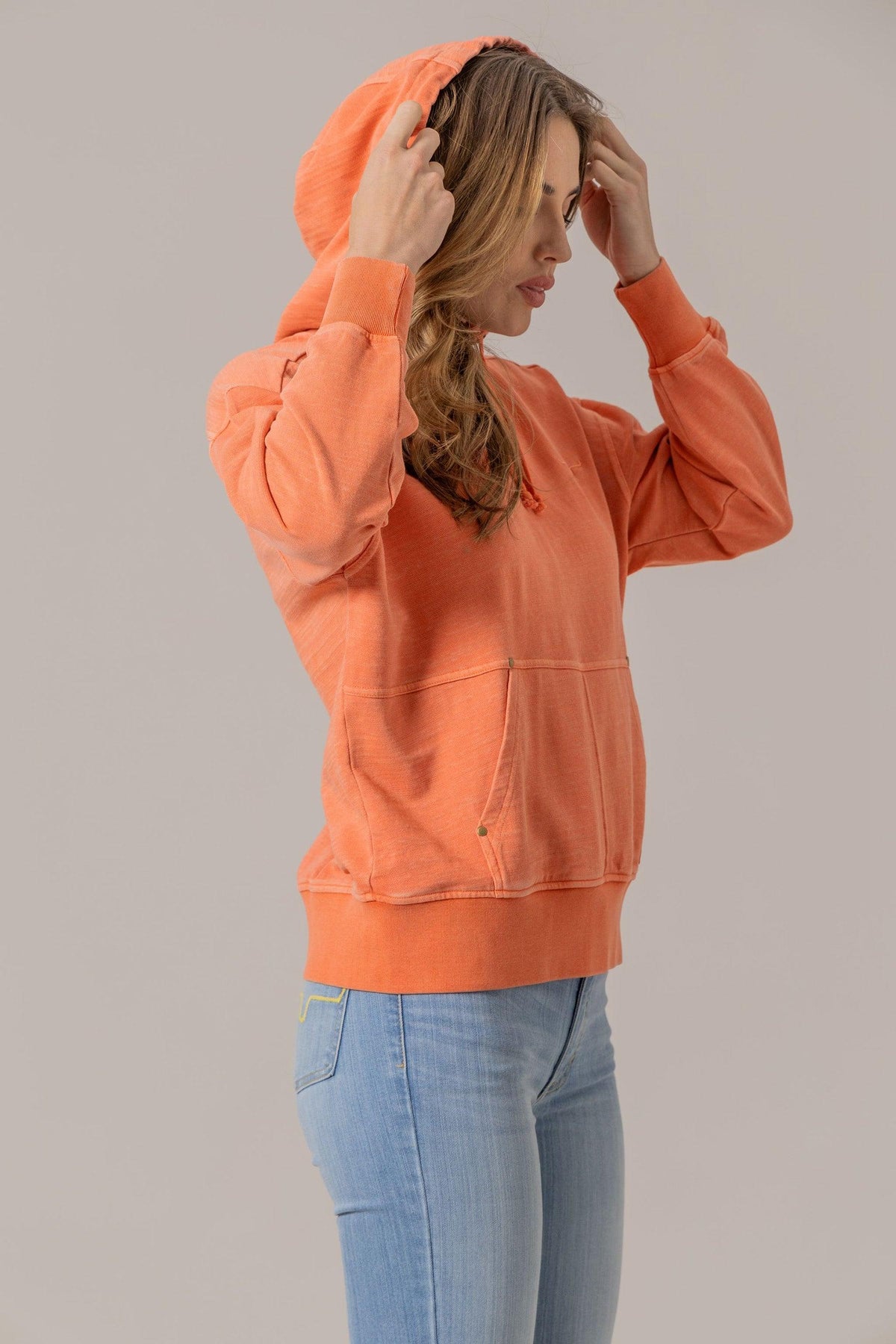 Kimes Ranch Tess Western Hoodie in Orange, side view, with a kangaroo pocket and ribbed cuffs
