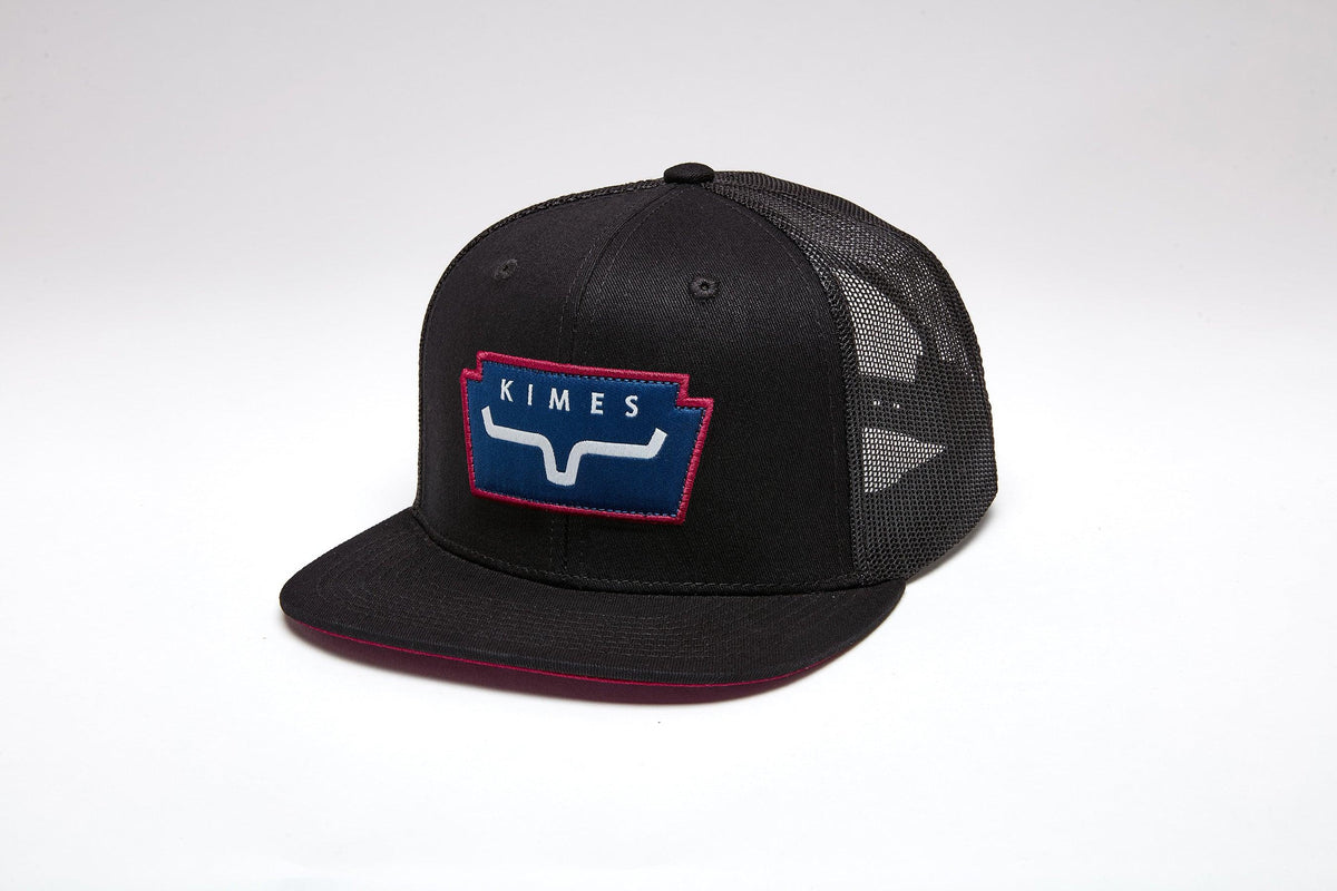 Kimes Ranch Texola Black trucker hat with a red and blue logo patch on the front