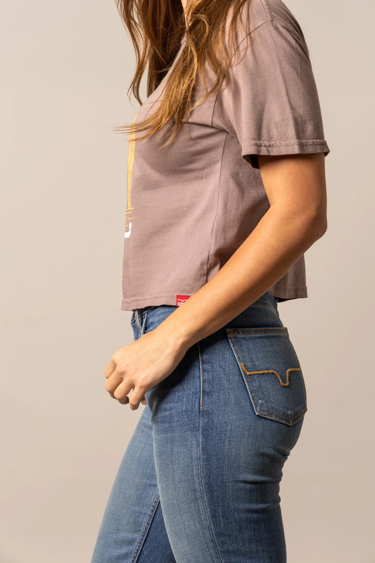 Kimes Ranch The Road shirt in Mocha, side view, with short sleeves and a red brand tag at the hem