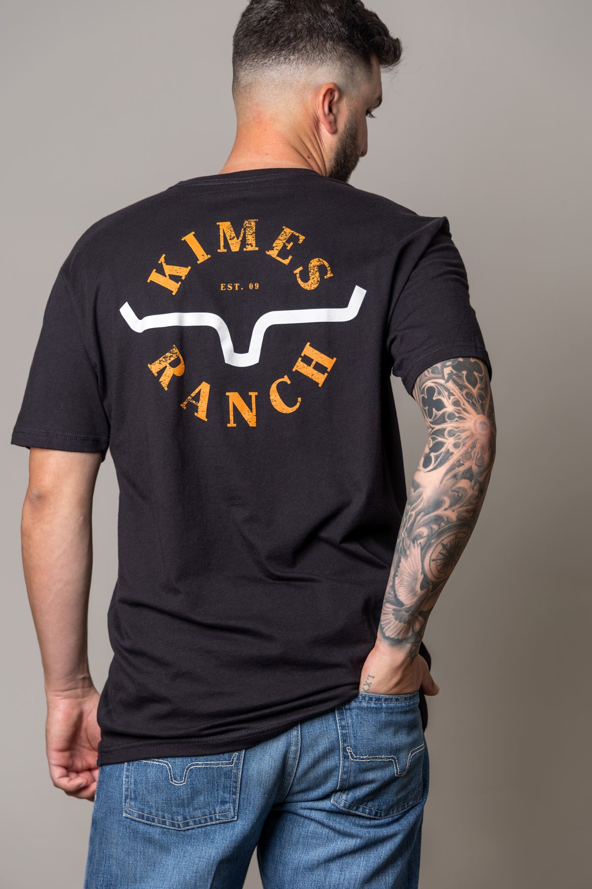 Kimes Ranch Uncomplicated shirt in Black, back view, with a back graphic featuring the Kimes Ranch logo and EST. 09 text