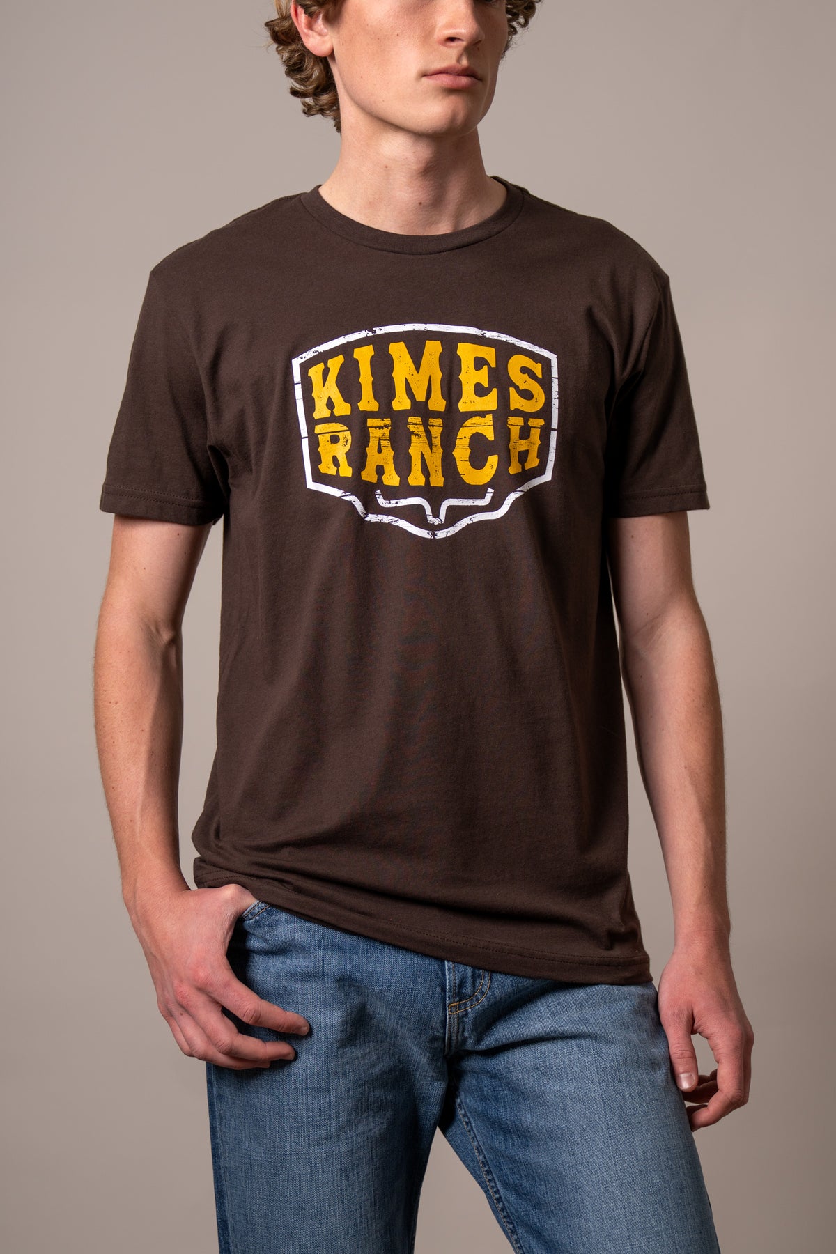 Kimes Ranch Wood Block shirt in Dark Chocolate with a large yellow and white Kimes Ranch logo on the chest