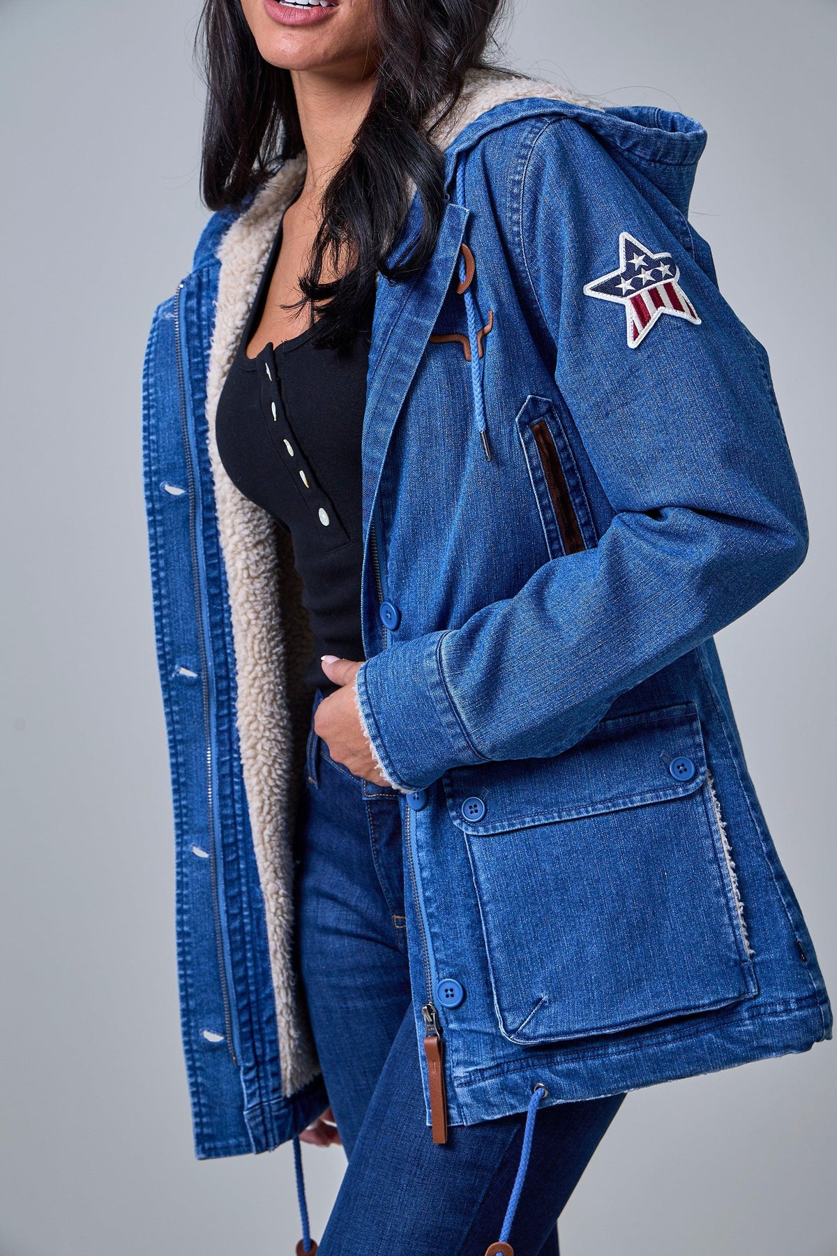 Kimes Ranch AWA Jacket in Light Wash Indigo, side view, with sherpa lining and a star patch on the sleeve
