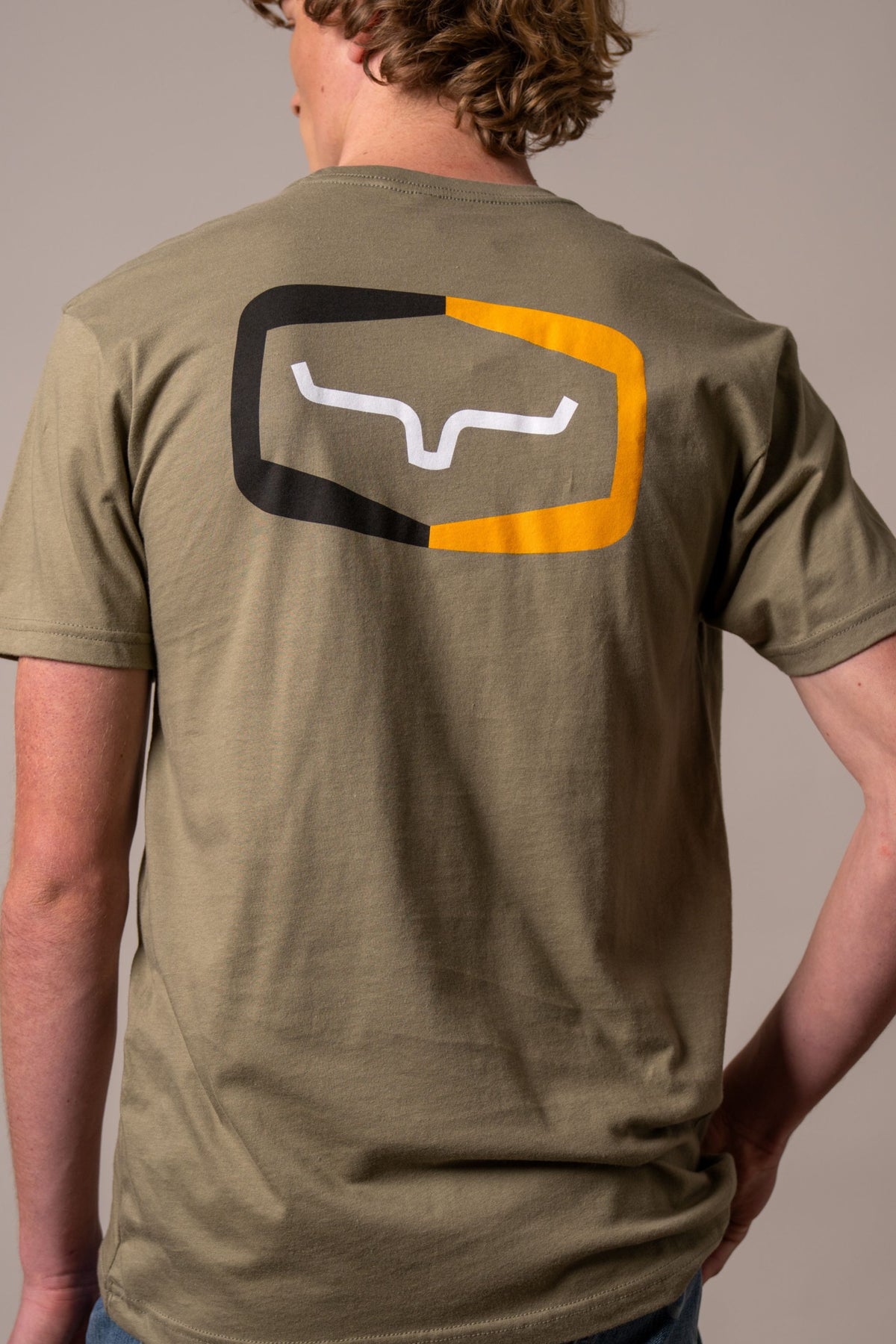 Kimes Ranch Framework shirt in Light Olive, back view, with a back graphic of a white Kimes Ranch logo inside a black