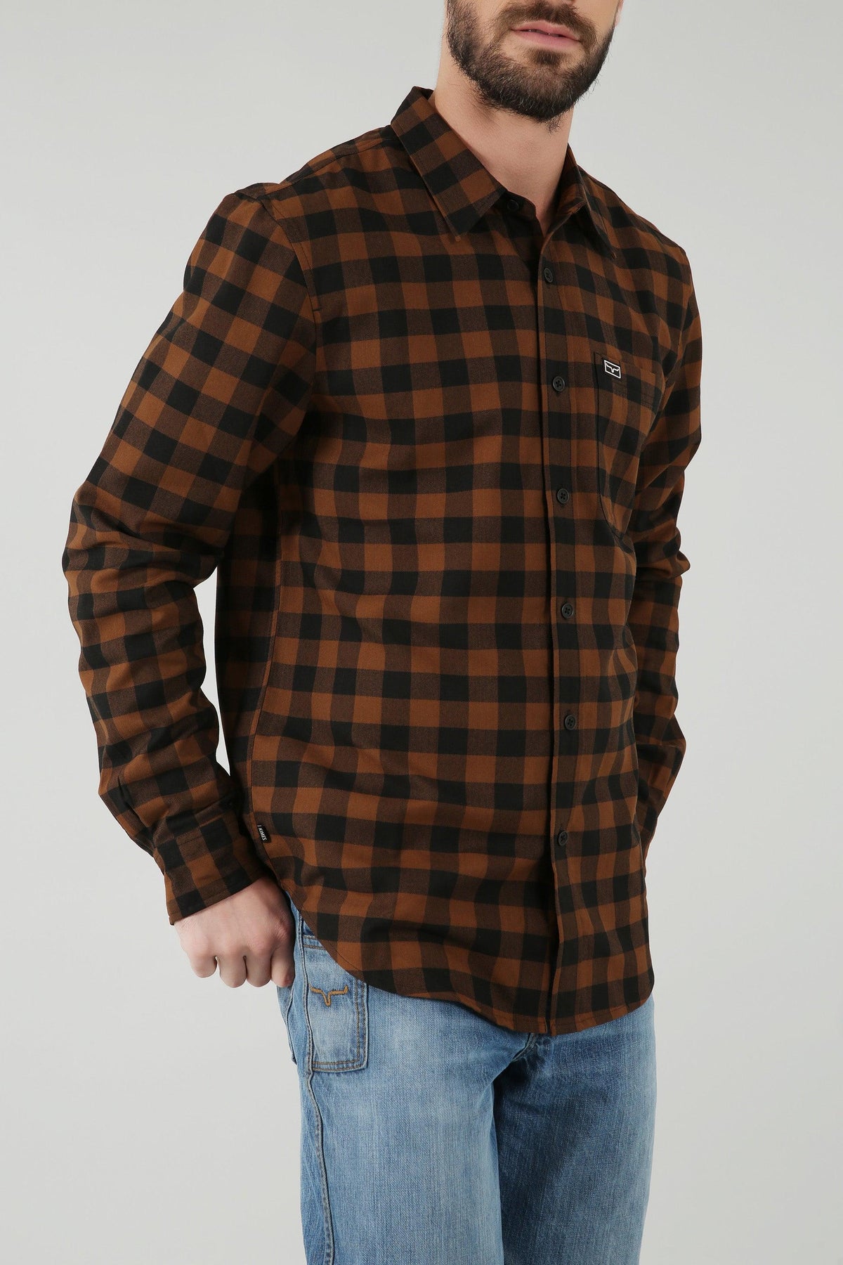 Kimes Ranch Garrison Dress Shirt in Brown, side view, with a black check pattern and a chest pocket with the Kimes Ranch logo