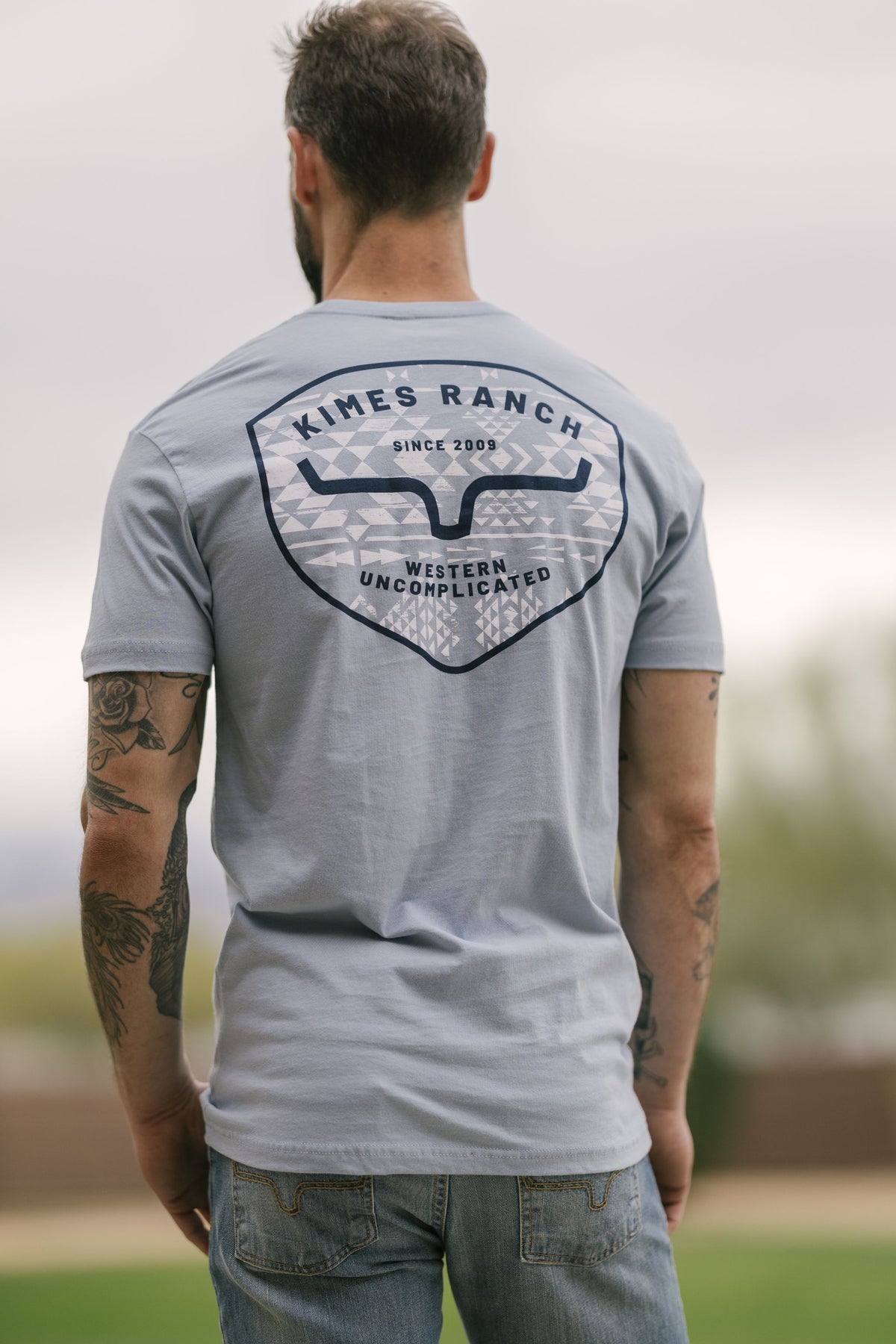 Kimes Ranch Honor, back view, shirt in Stonewash with a back graphic featuring the Kimes Ranch logo