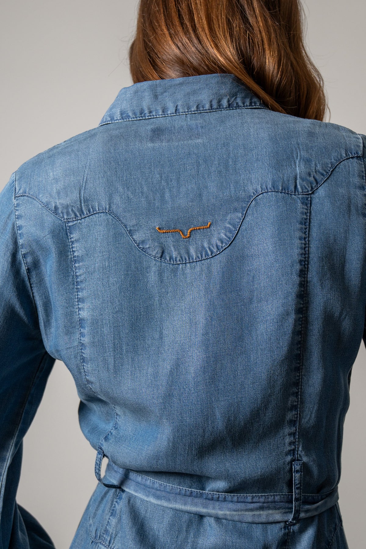 Kimes Ranch Channy denim skirt back view featuring a decorative yoke with the brand logo embroidered in orange