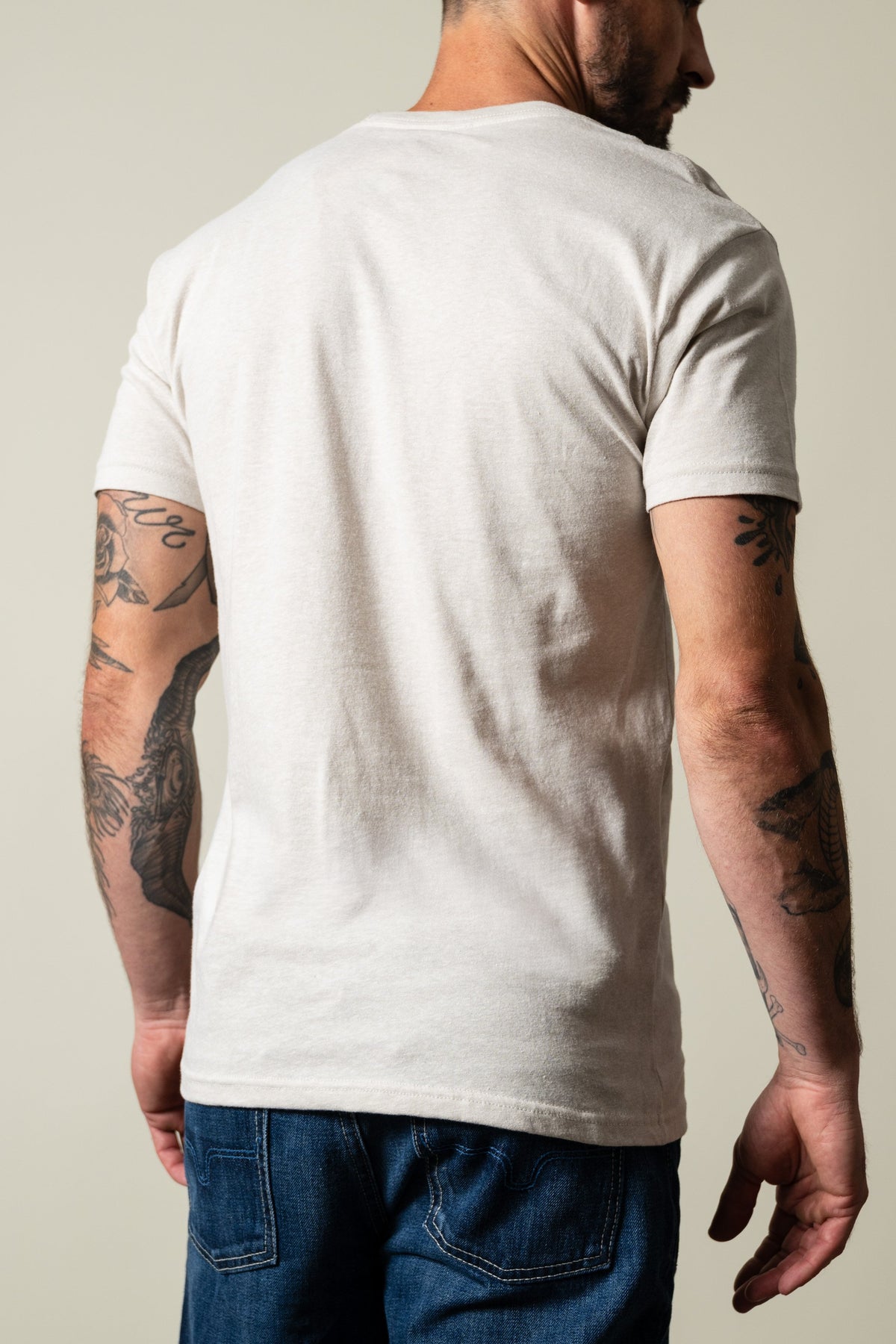 Kimes Ranch Davona Dale shirt in sand, short sleeve crew neck, plain back with ribbed cuffs, model viewed from behind