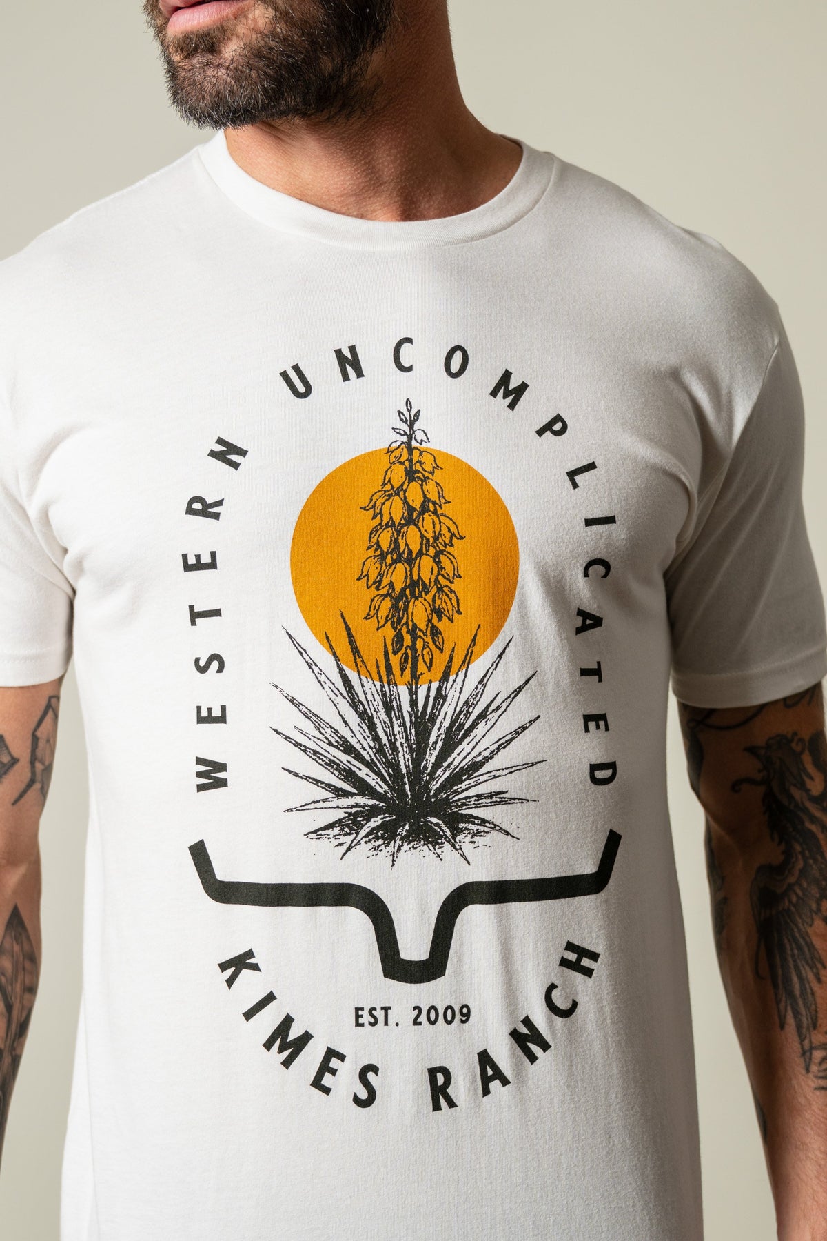Kimes Ranch Drought Resistant bone t-shirt with graphic of a yucca in a yellow circle above the Kimes Ranch logo