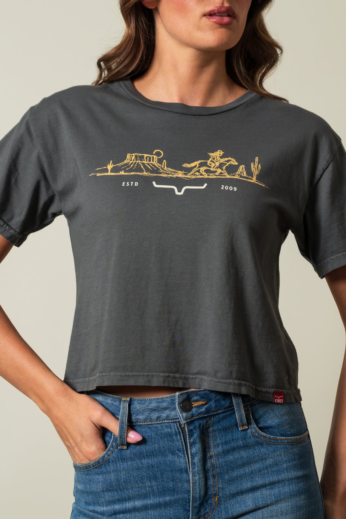 Kimes Ranch Go West shirt in Pepper, short-sleeved crewneck with a gold graphic of a western scene and Kimes Ranch logo