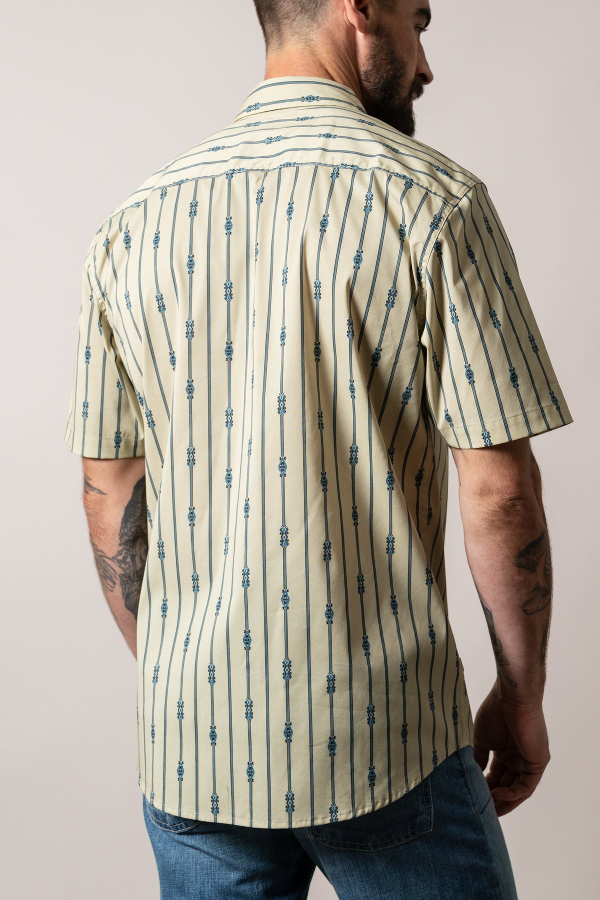 Kimes Ranch Gunner dress shirt, khaki with vertical blue pinstripes and small geometric motifs on the back