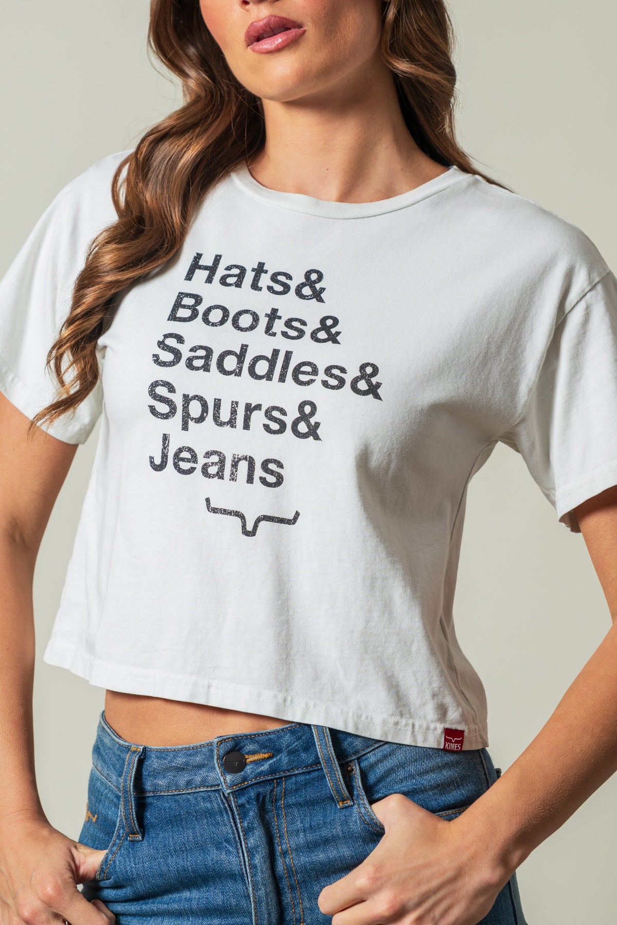 Kimes Ranch Hats & Boots short sleeve natural graphic tee with stacked text reading Hats & Boots & Saddles & Spurs & Jeans